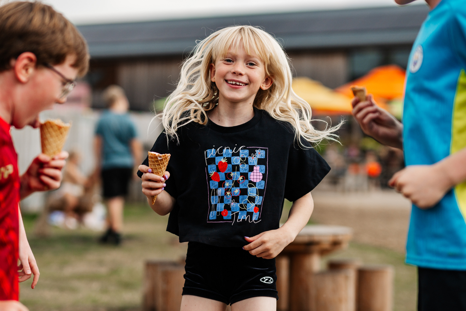 Children enjoying ice cream at a sunny outdoor café