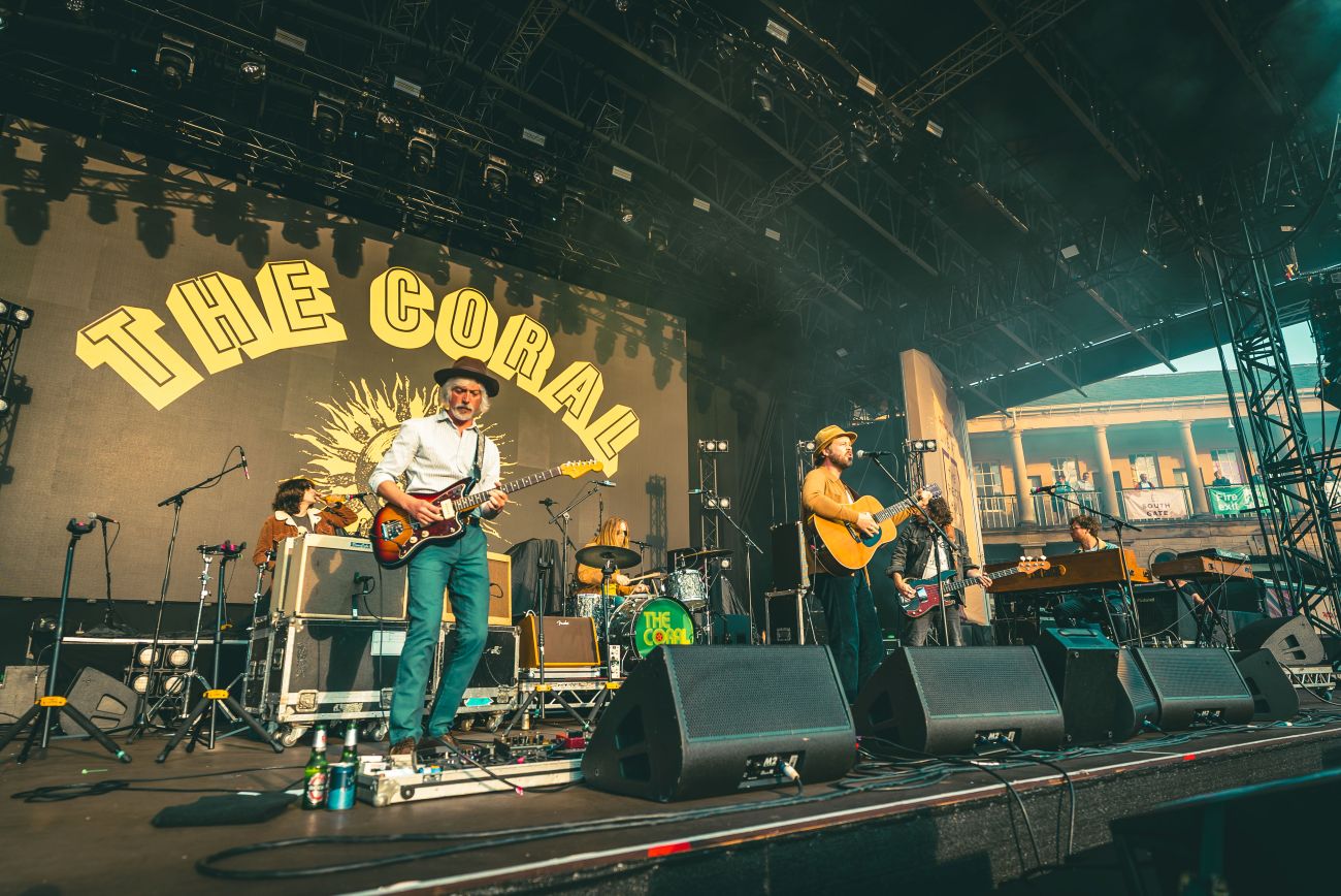 Band performing on an outdoor stage with large crowd