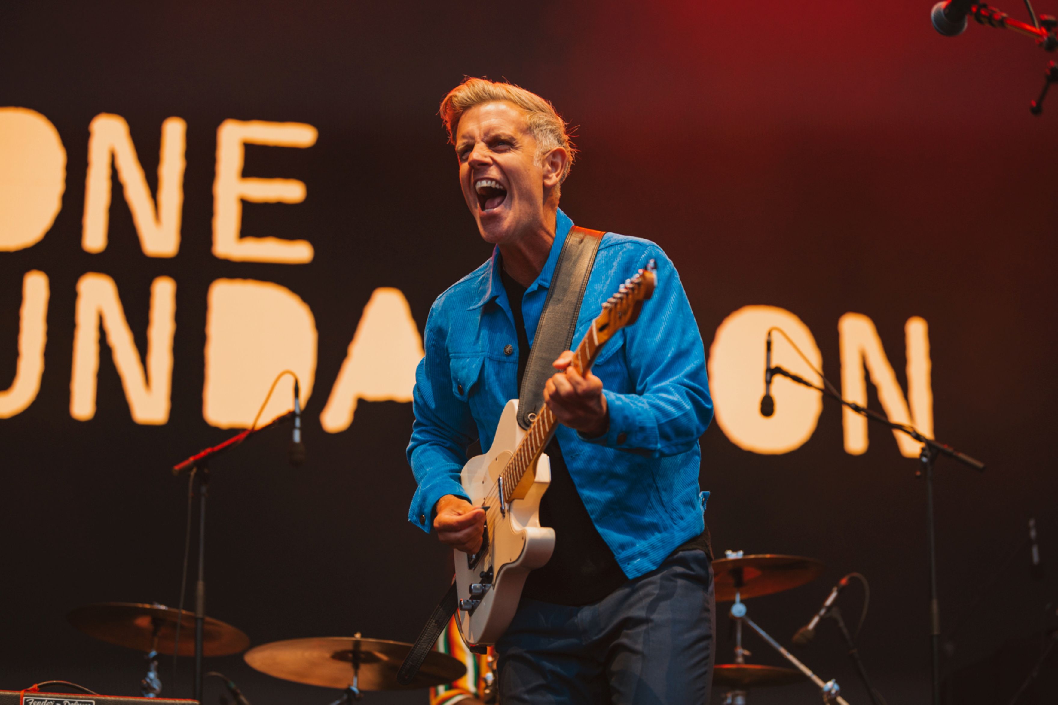 Musician passionately playing electric guitar on stage