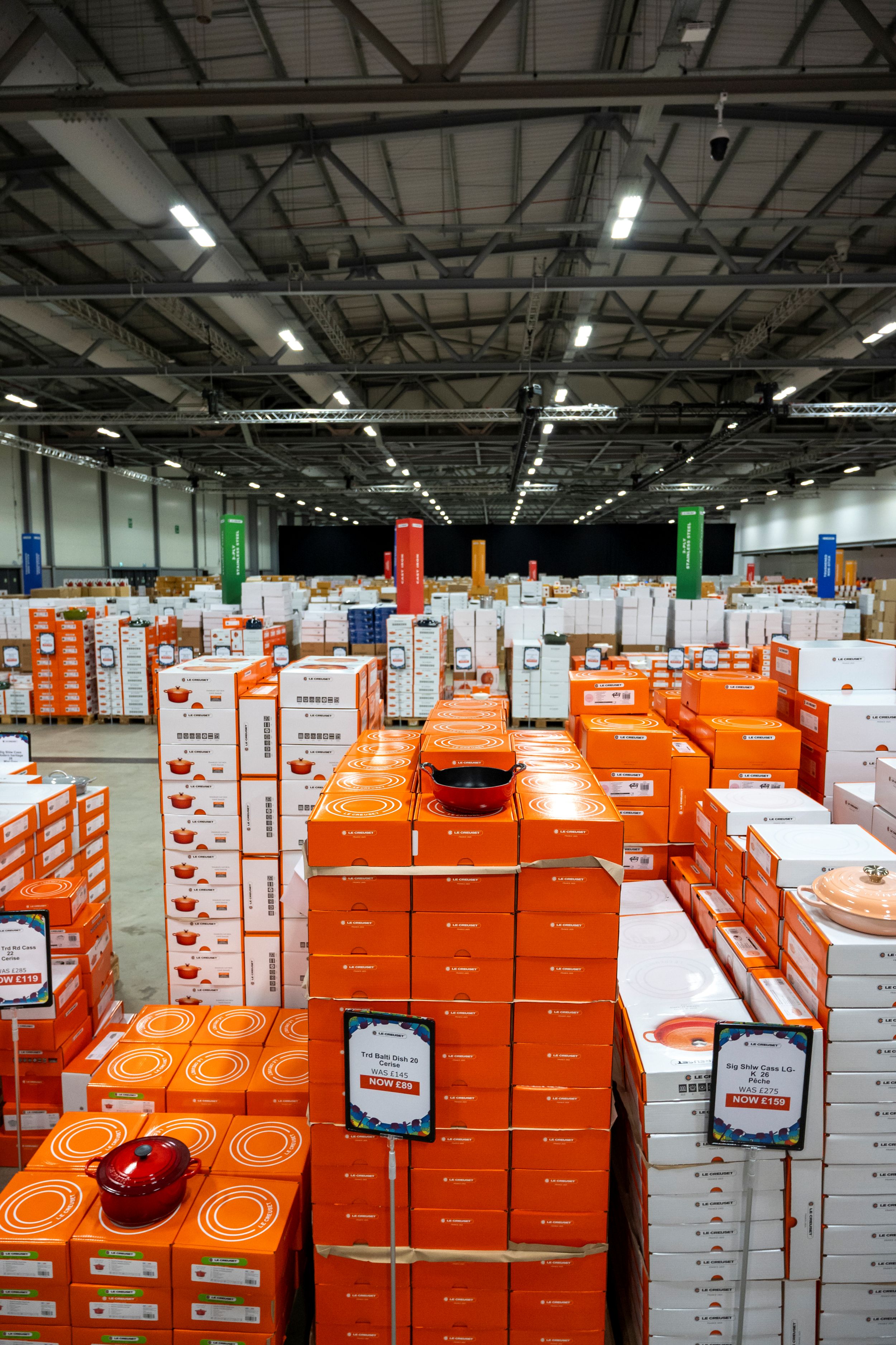 Warehouse interior with stacked orange and white boxes under ceiling lights