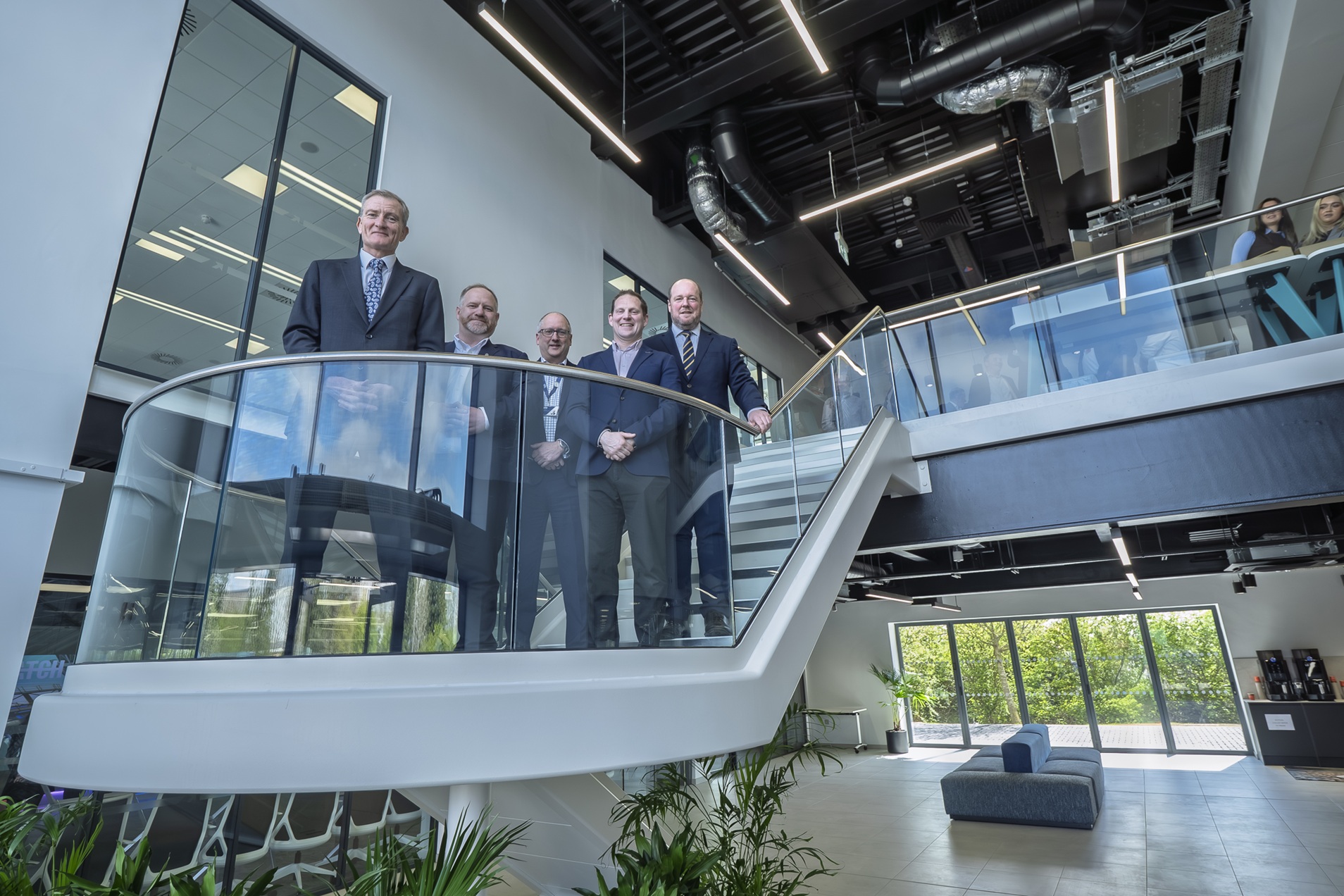 Modern office interior with glass staircase and group of people