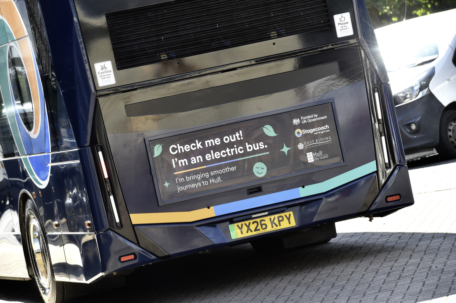 Electric bus with eco-friendly signage parked on a street