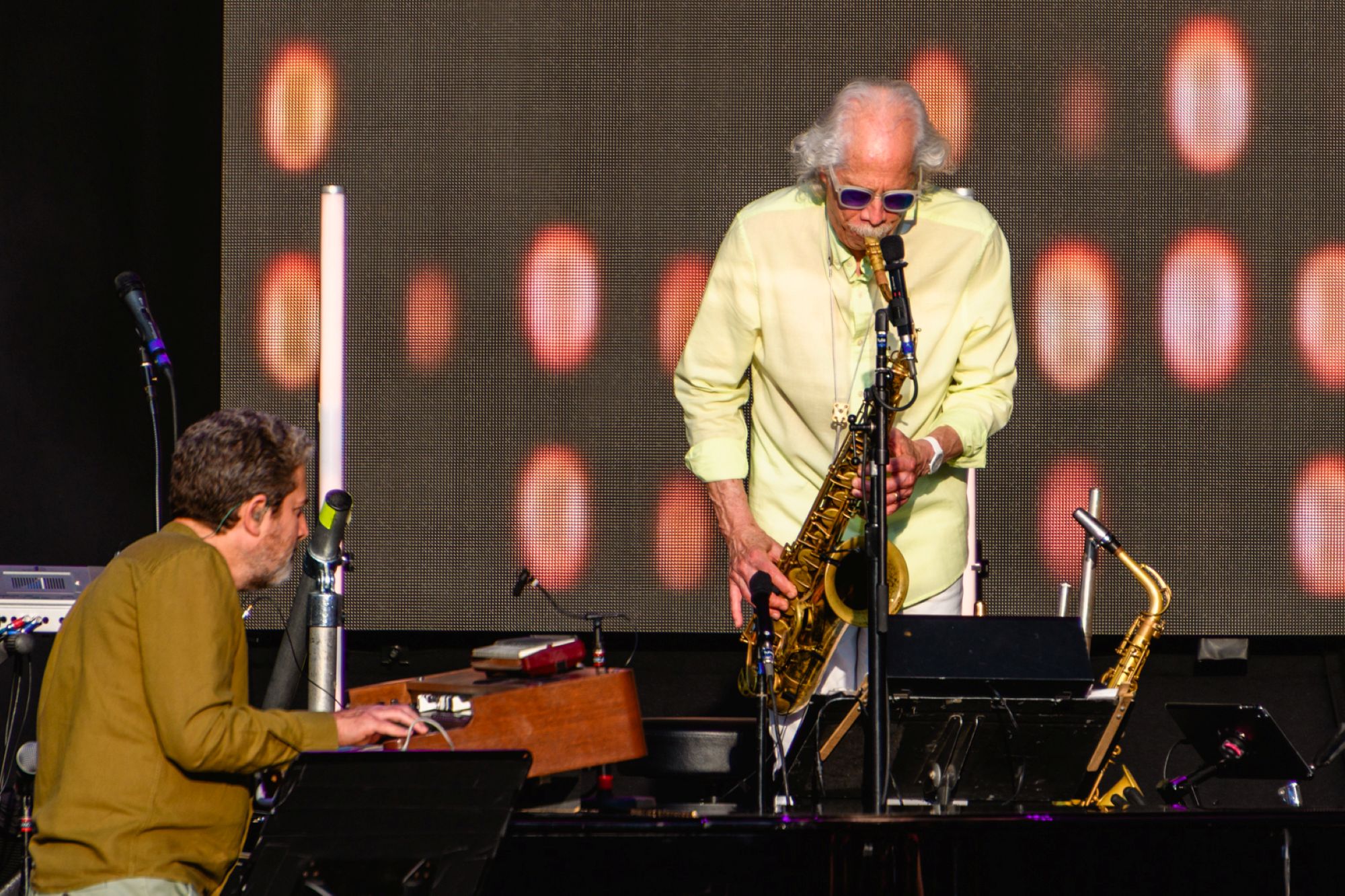Jazz musician playing saxophone on stage with keyboard player