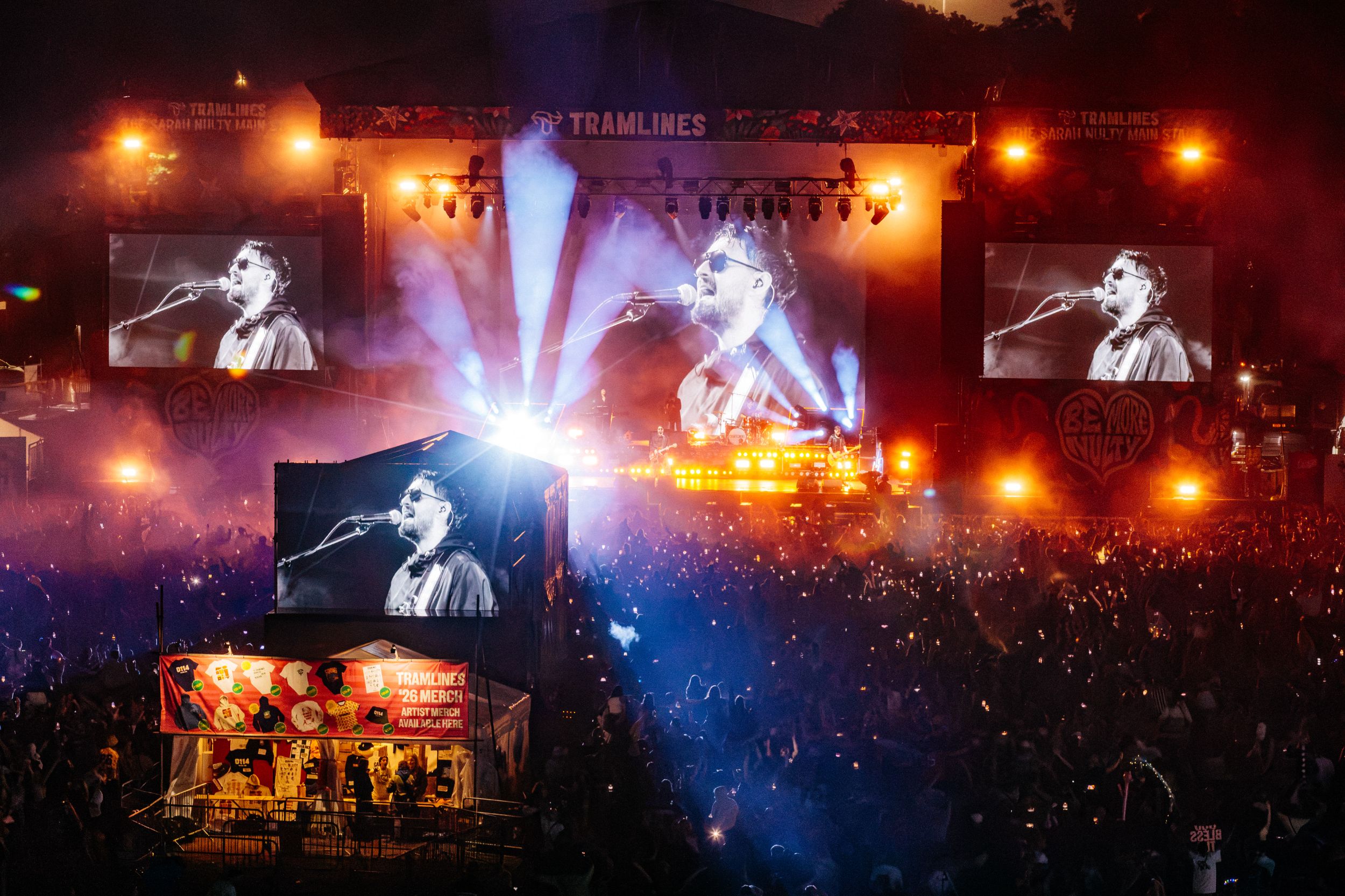 Crowd at an outdoor concert with vibrant stage lights