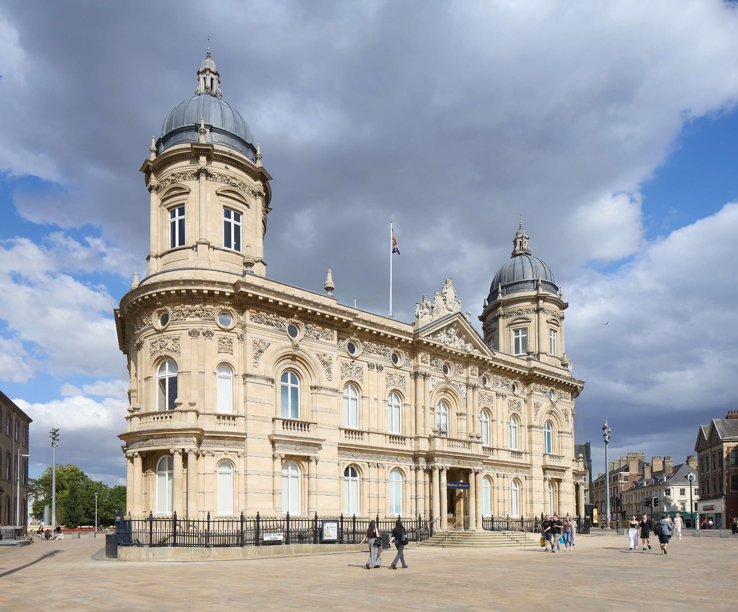 Historic Victorian building with domed towers under a cloudy sky