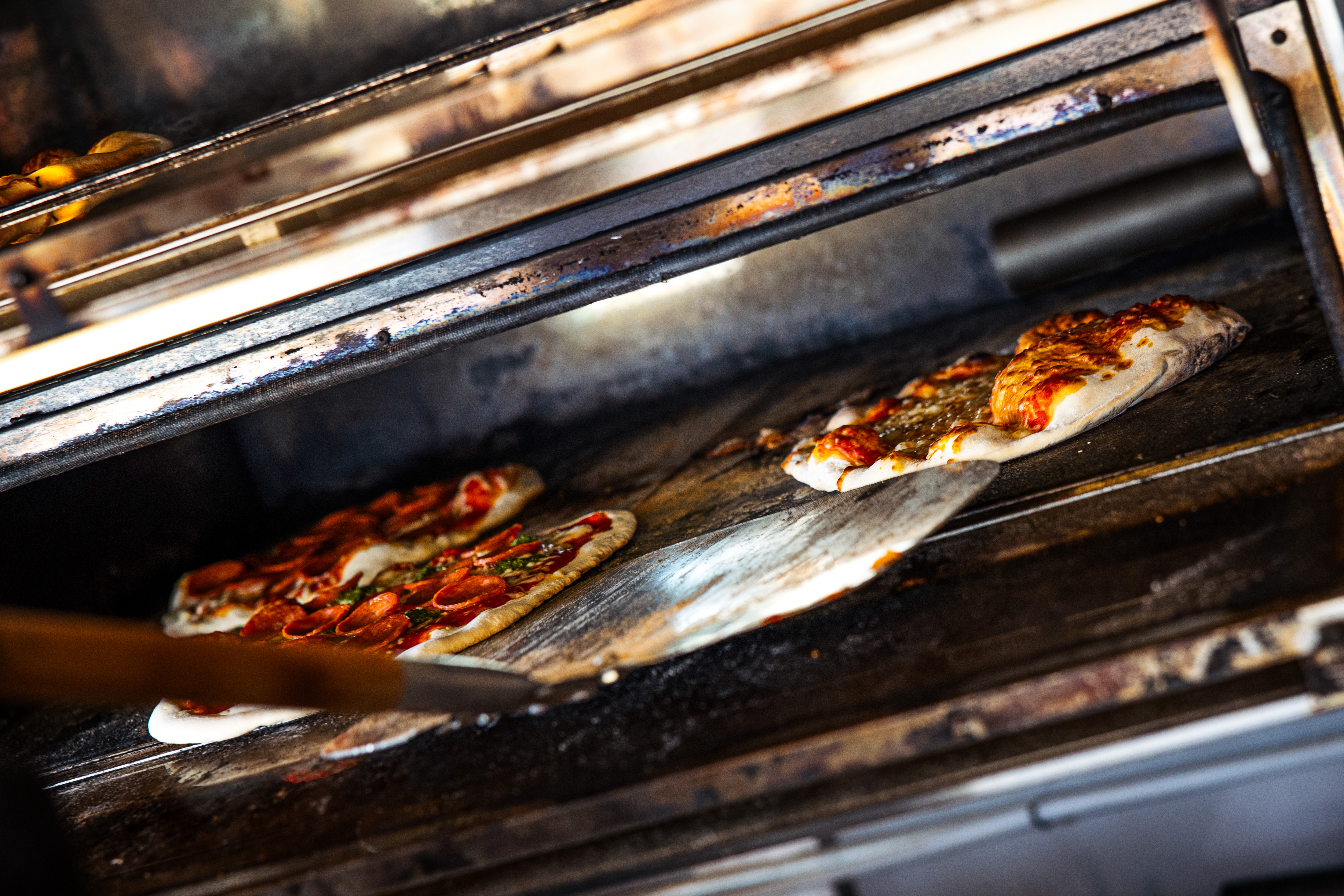 Wood-fired oven with freshly baked pizzas inside
