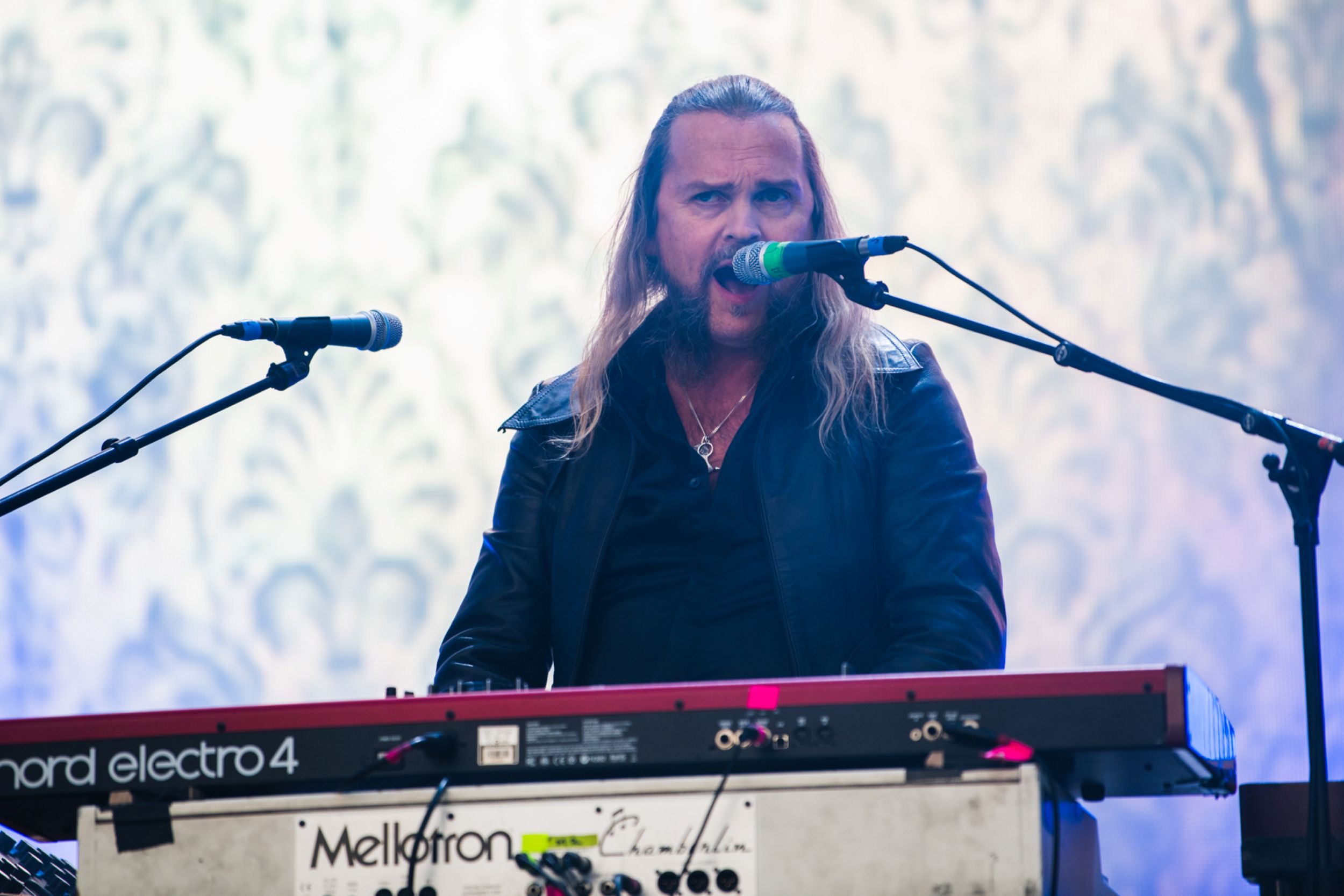 Musician with long hair playing keyboard on stage