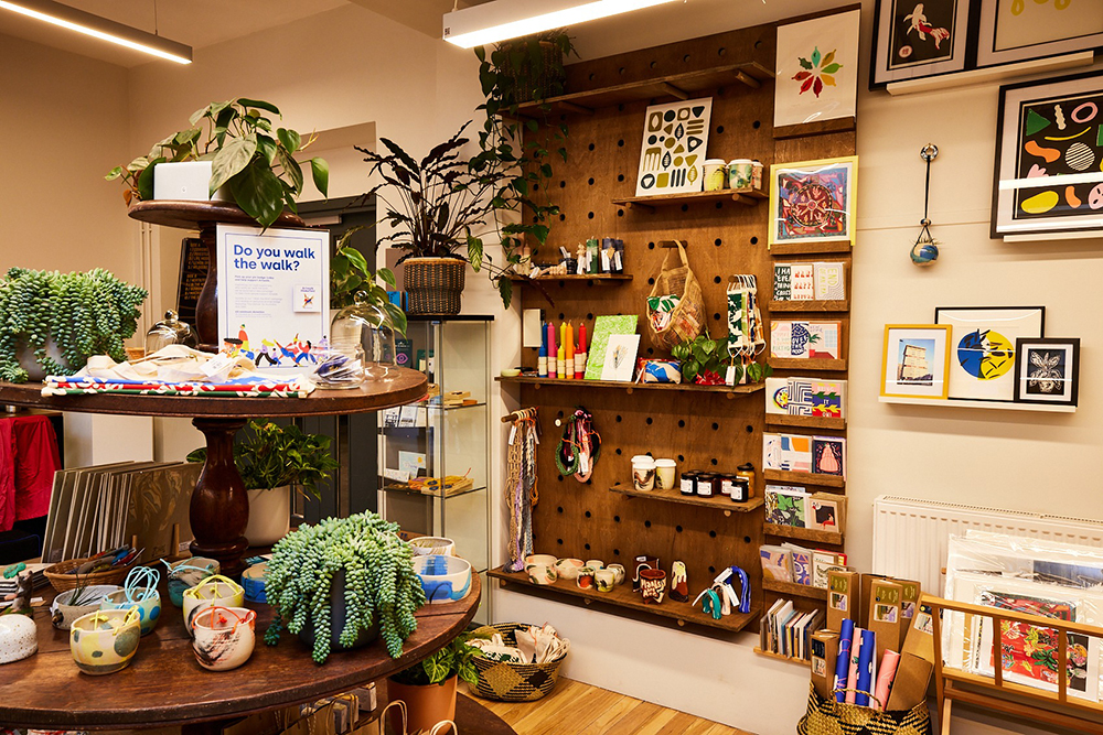 Cosy shop interior with plants, art prints, and handmade crafts