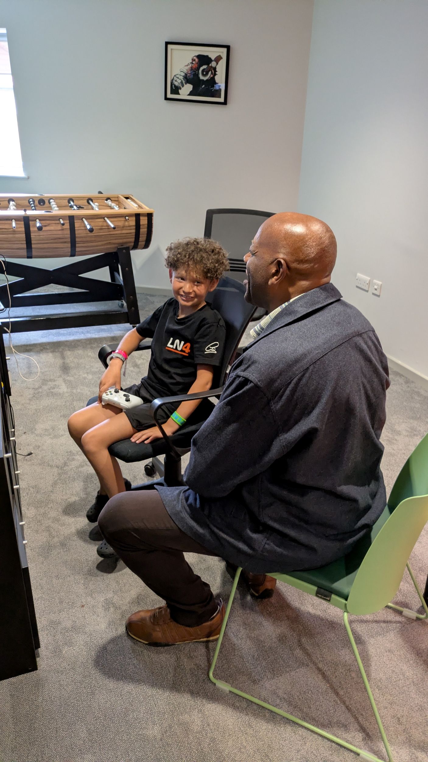 Smiling child and adult playing video games in cosy room