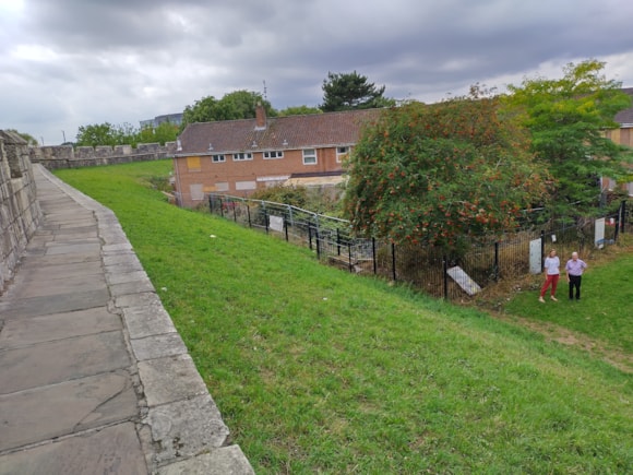 View from York city walls with grassy path and historic buildings