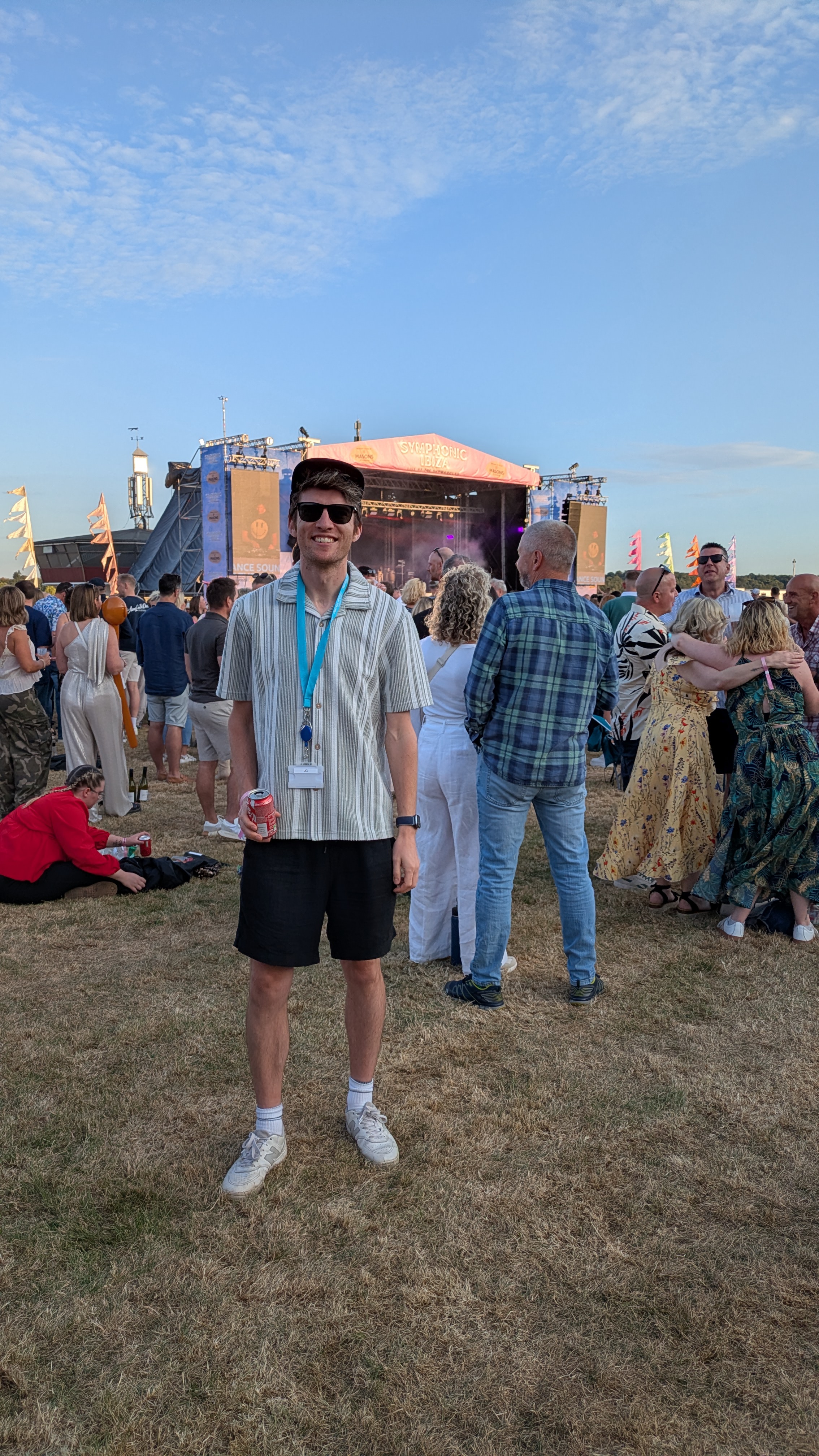 Outdoor music festival with crowd, stage and blue sky