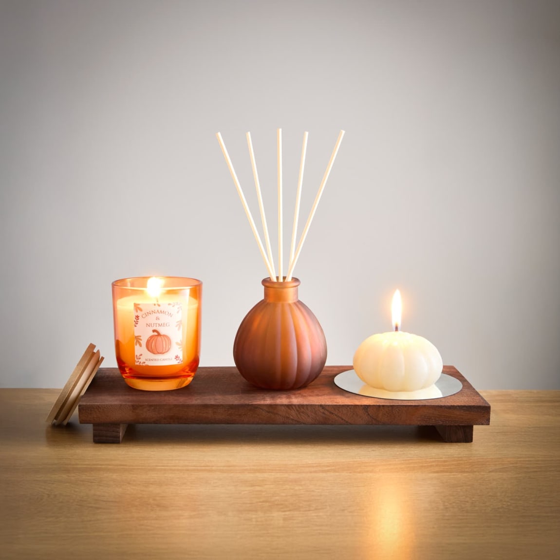 Autumn scented candle and diffuser on wooden tray