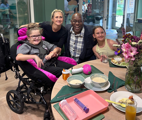Smiling family at a dining table with flowers and food