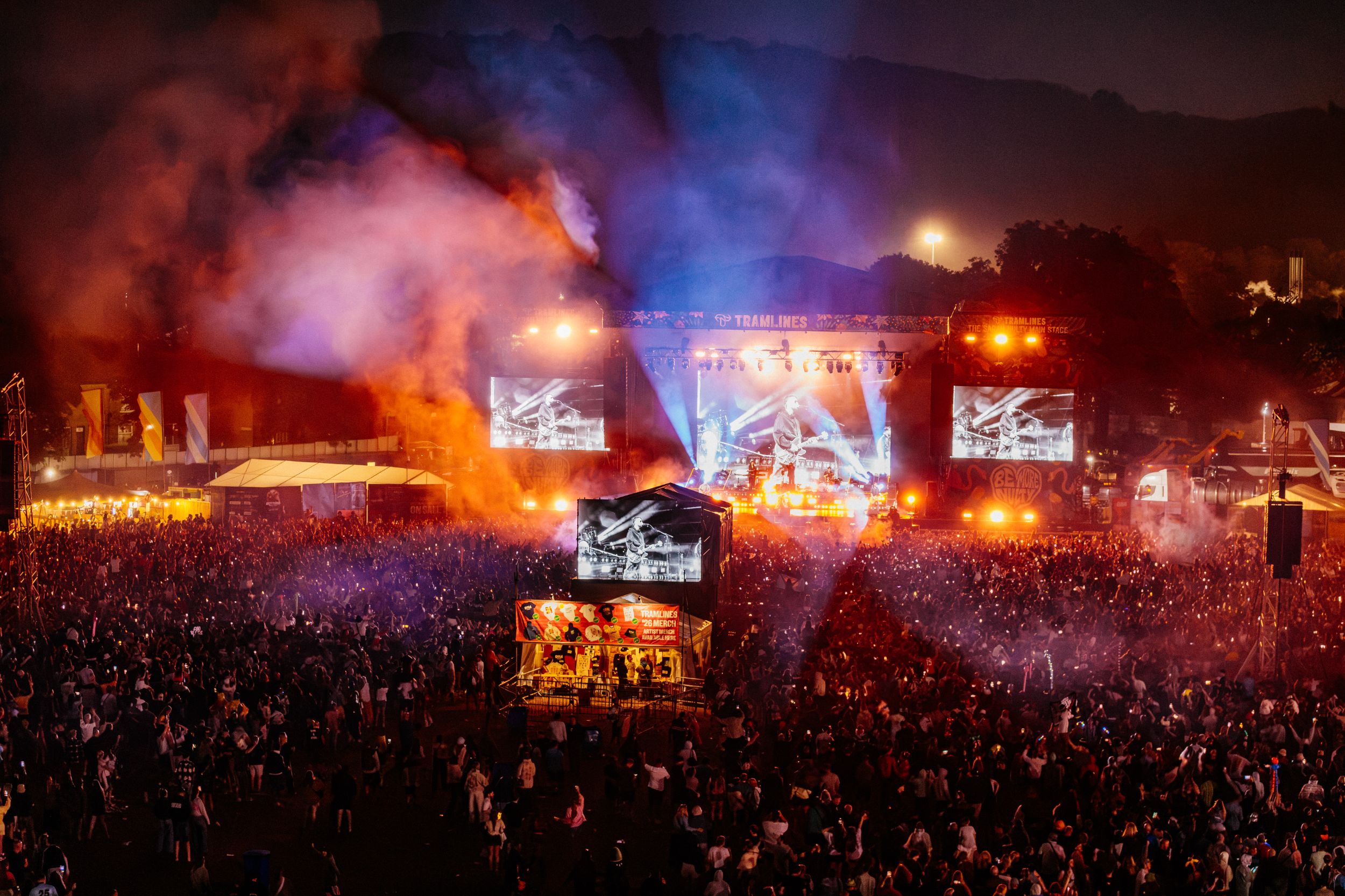 Crowded music festival at night with vibrant stage lights