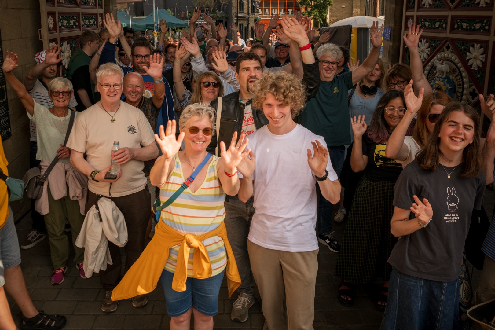 Smiling group of people waving at a street market in Yorkshire