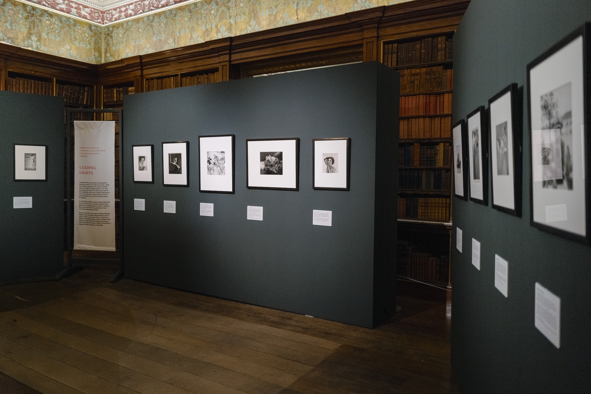 Art gallery room with framed black and white photographs on dark walls