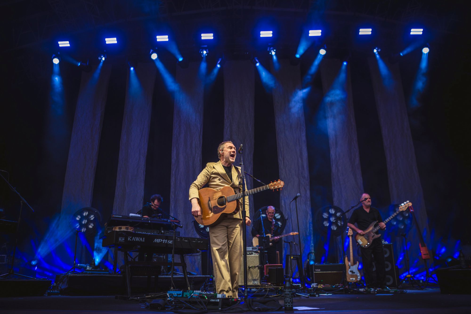 Live band performing on stage with vibrant blue lighting
