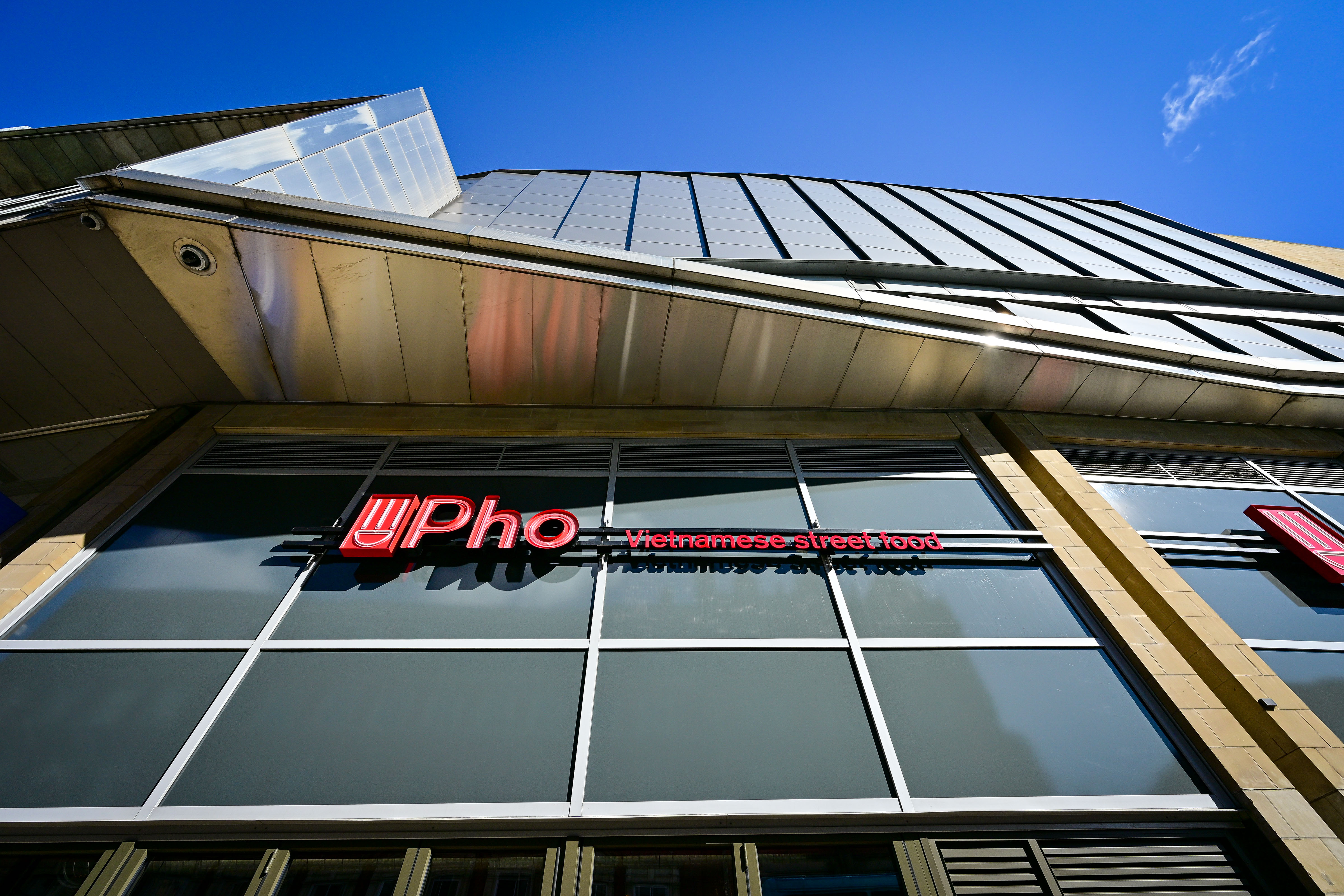 Modern building with large windows and red street food sign
