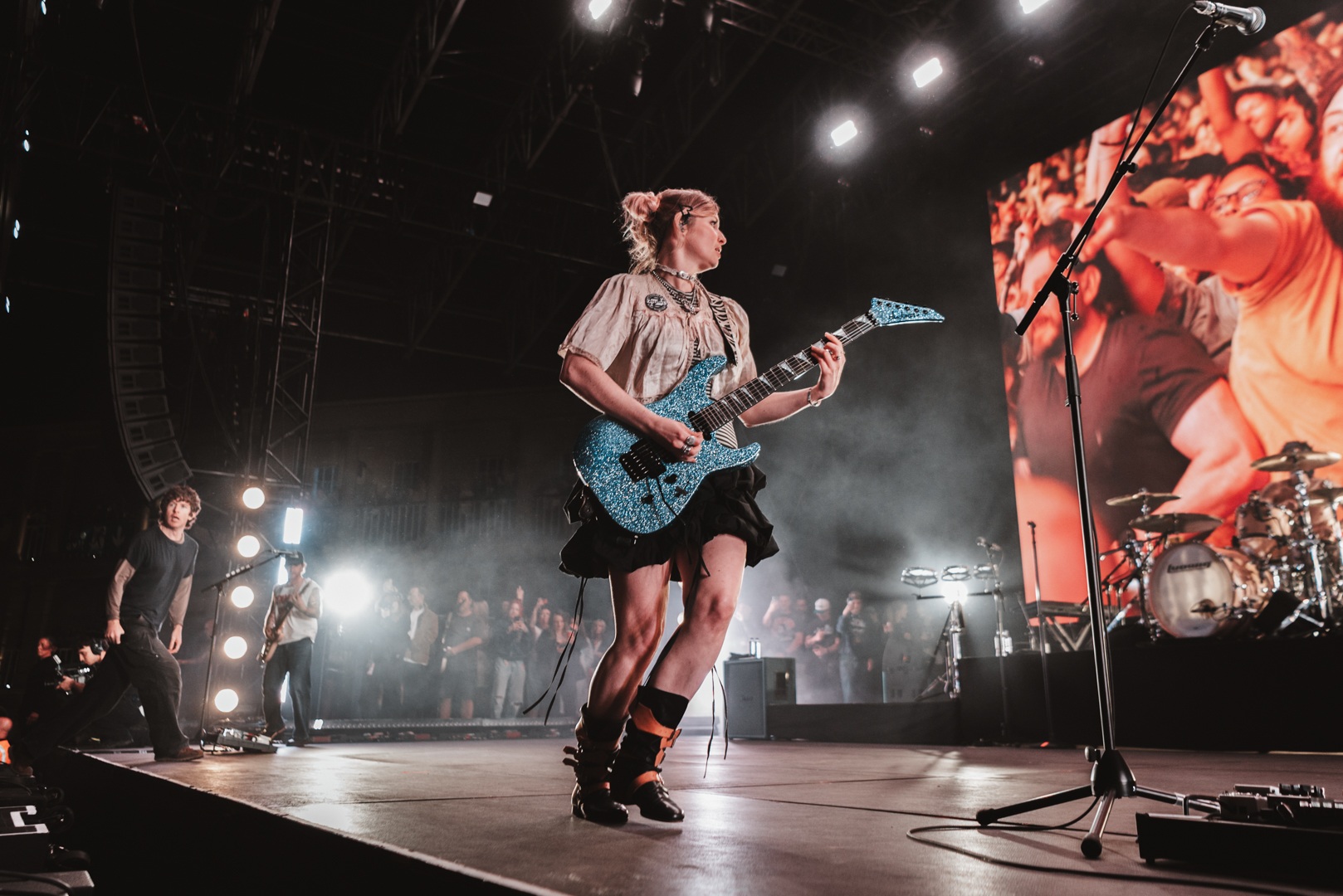 Guitarist on stage with blue electric guitar during concert