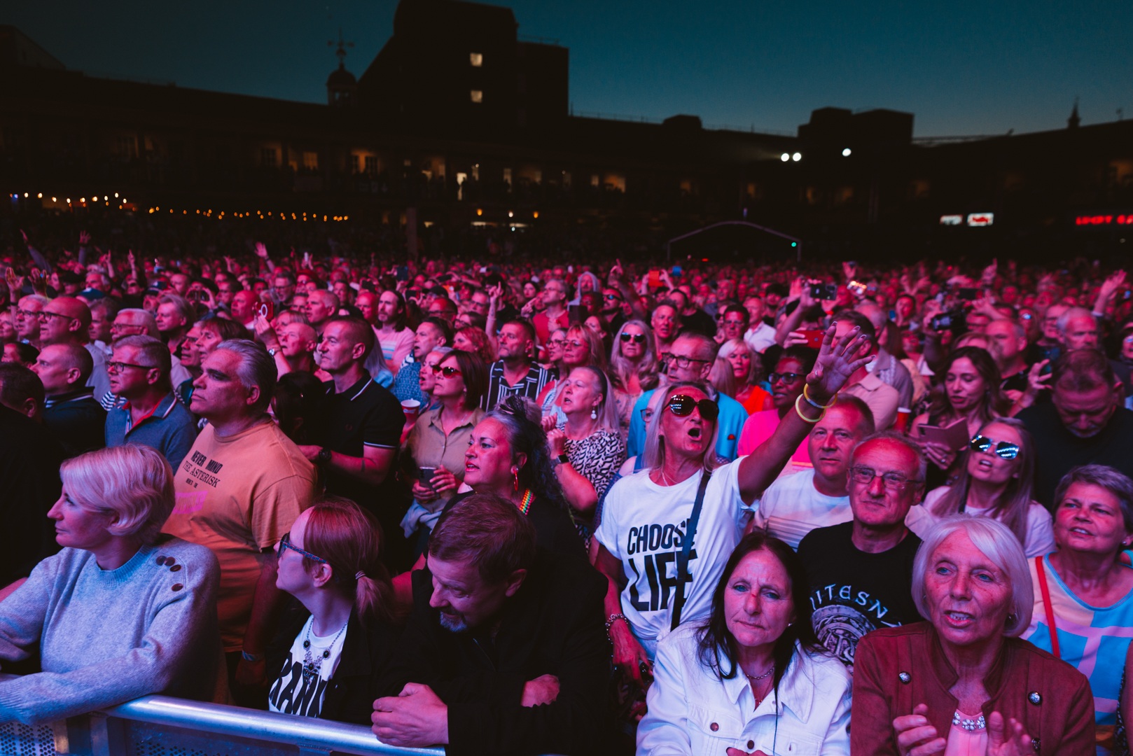 Crowd of people enjoying an outdoor concert at dusk