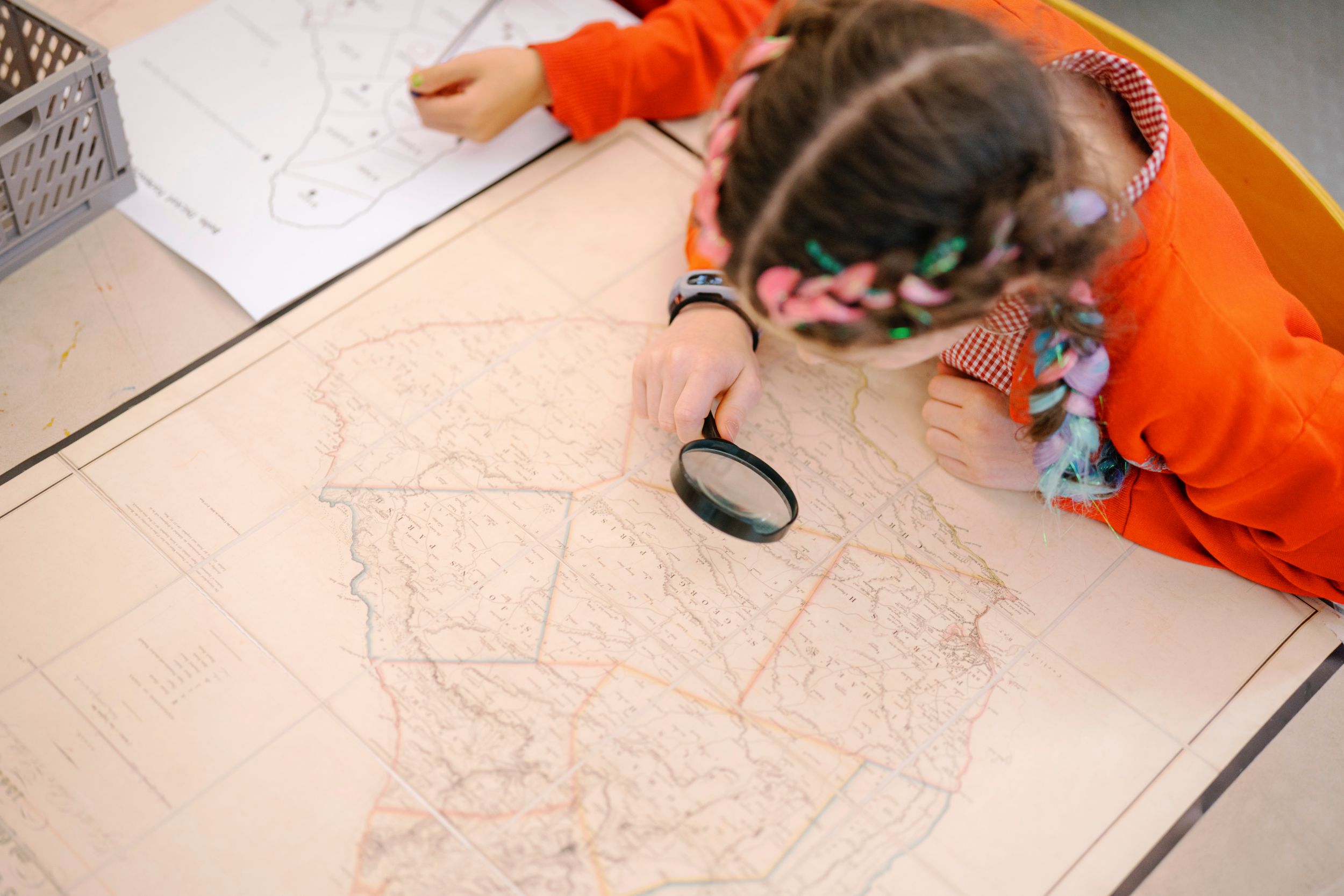 Child with braided hair examining a vintage Yorkshire map