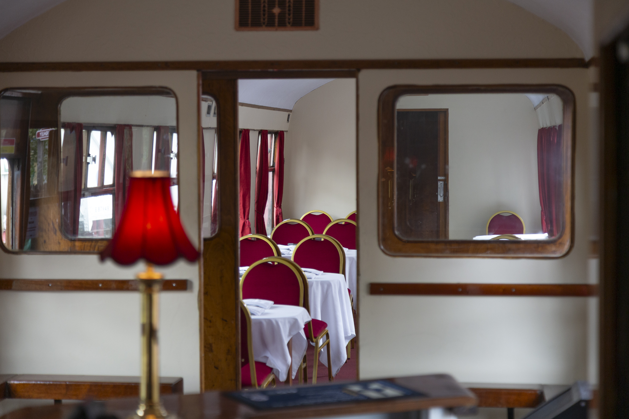 Vintage train dining carriage with red velvet chairs and lamp