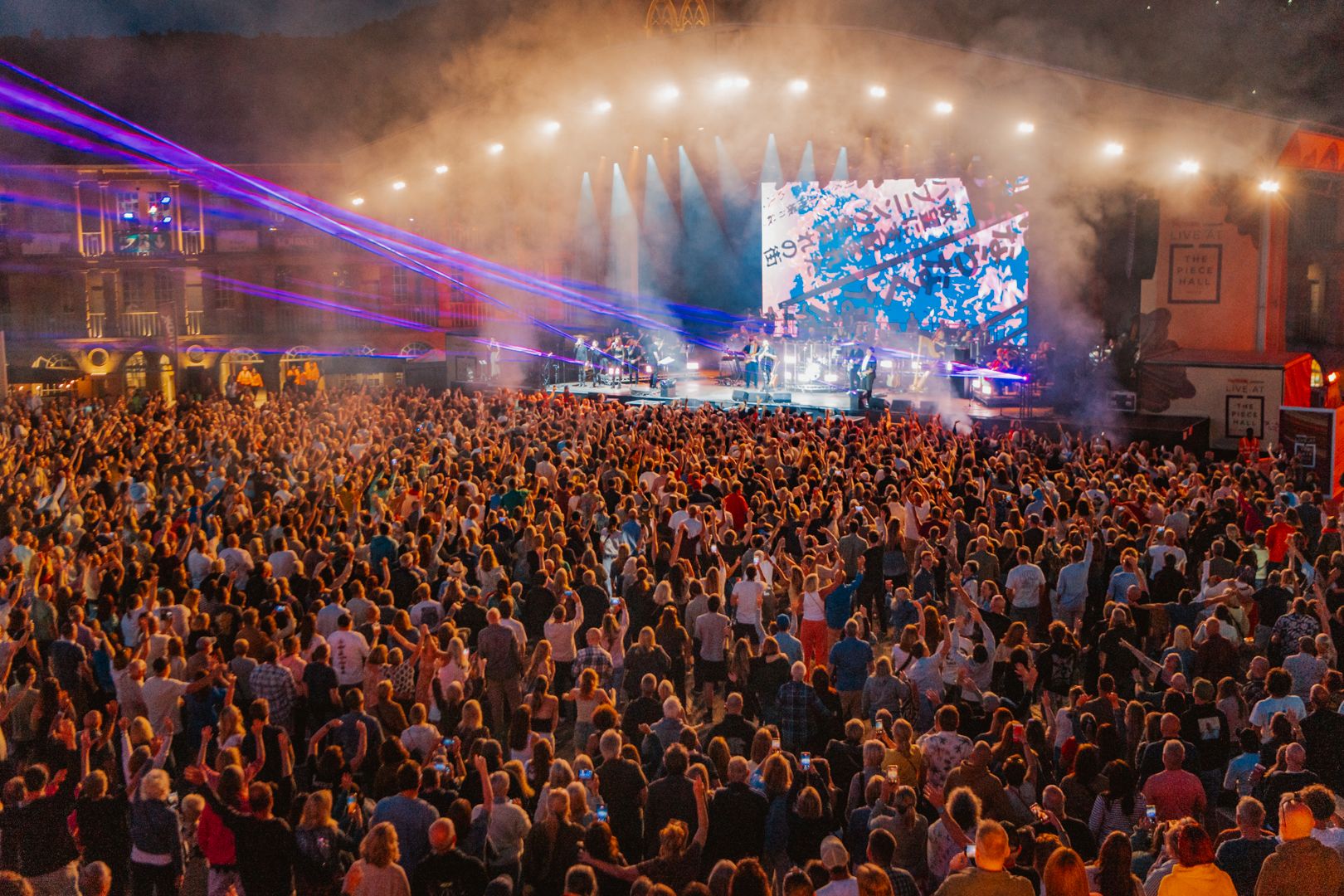 Crowd enjoying a lively outdoor music concert at night