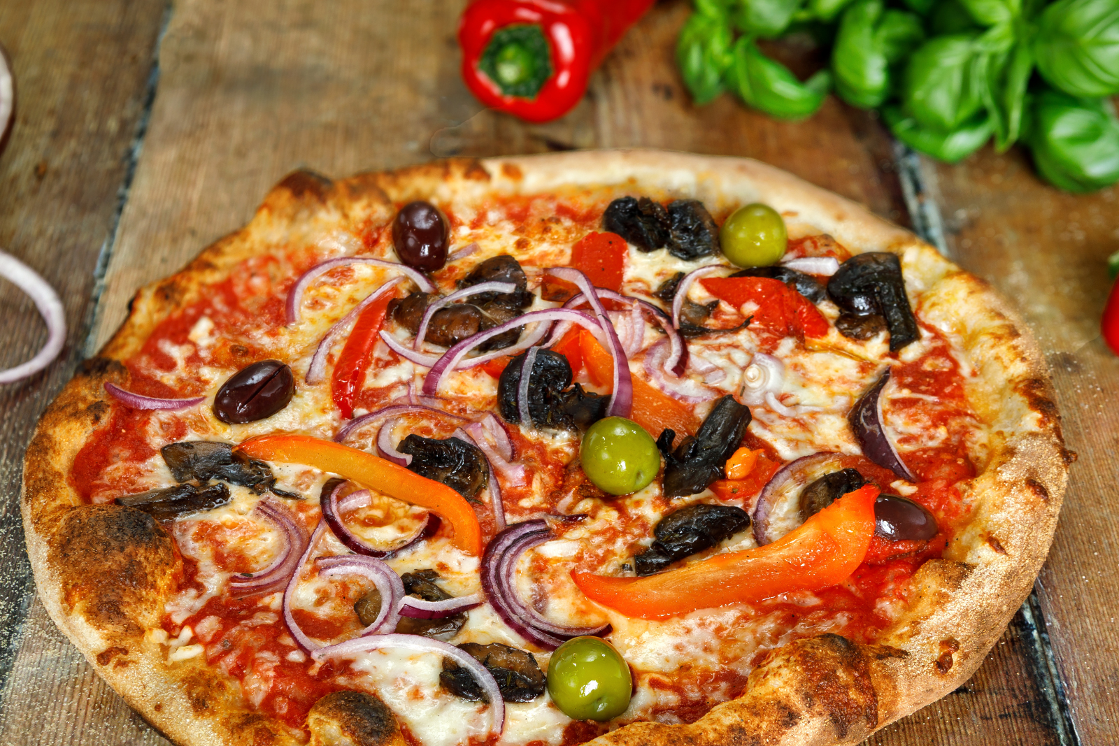 Wood-fired pizza with olives, red peppers, and onions