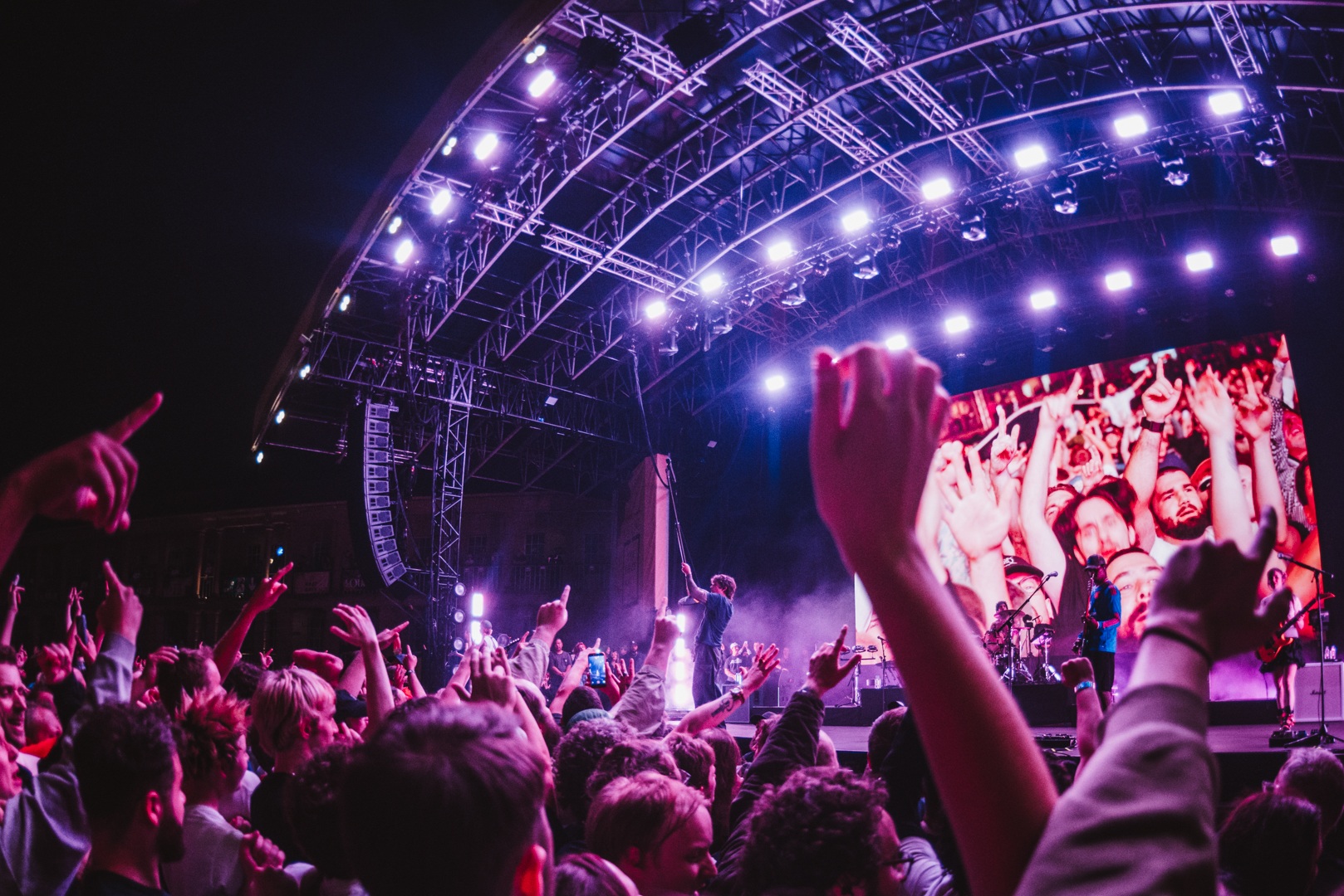 Crowd enjoying a live music concert under vibrant stage lights