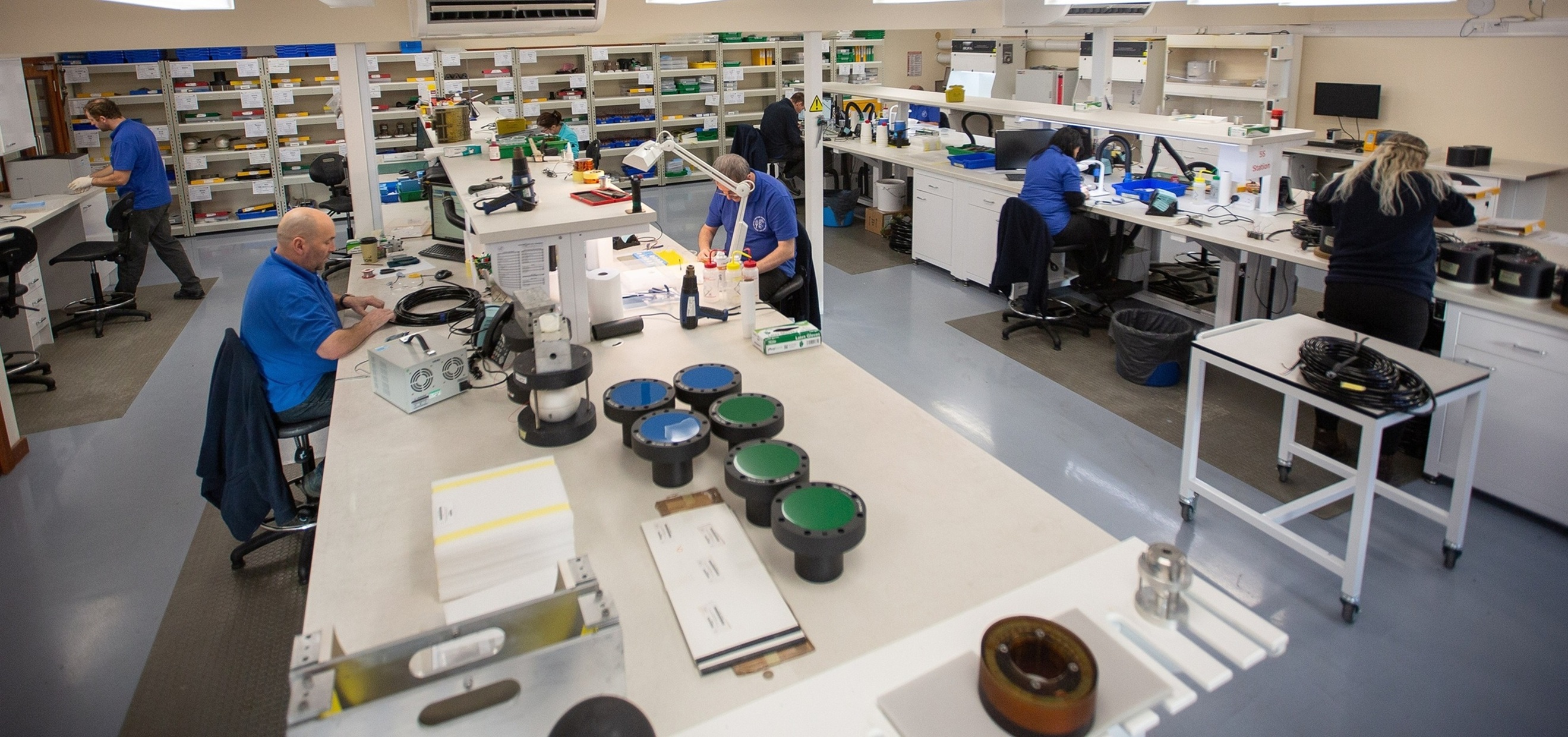 Technicians in a laboratory assembling optical equipment