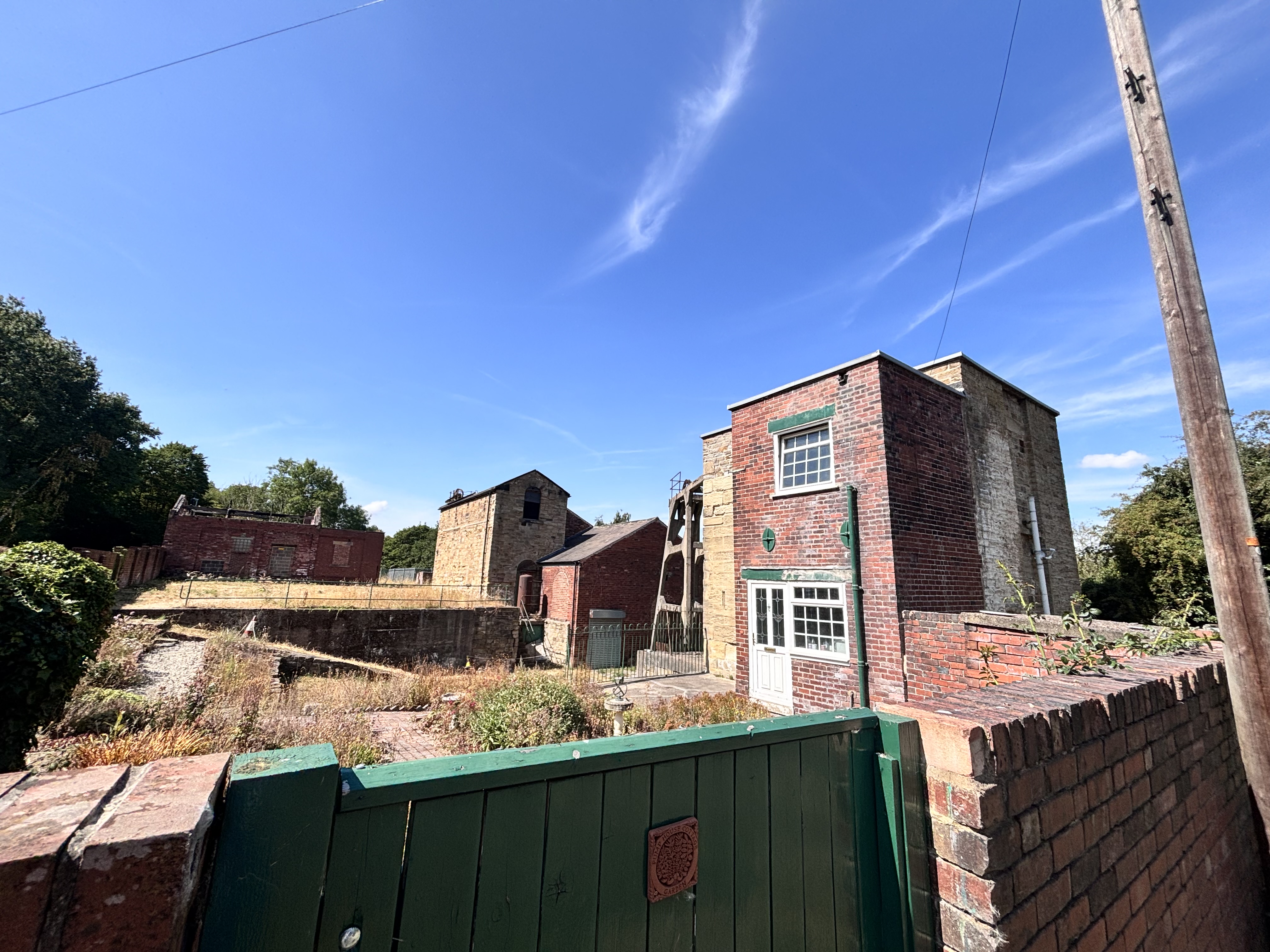Historic red brick buildings with green gate under blue sky