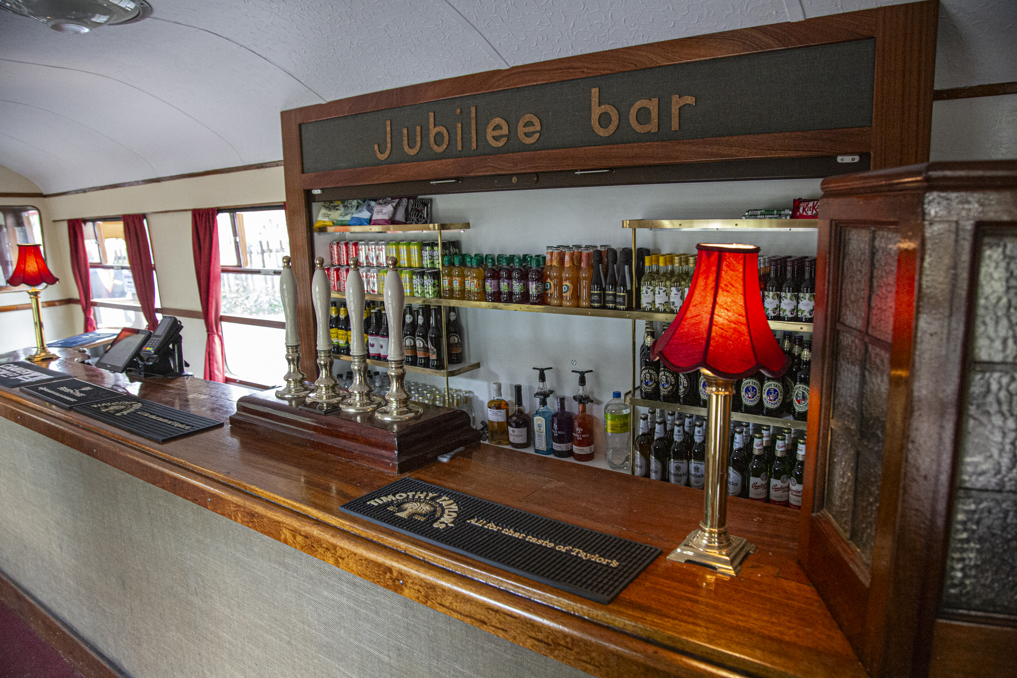 Traditional pub bar with wooden counter and red lampshades