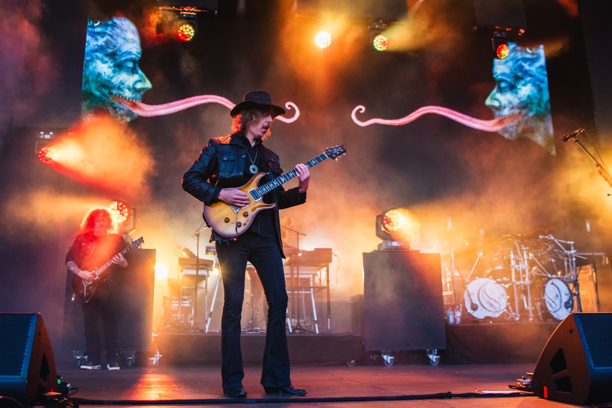 Rock band performing with vibrant stage lights and artistic backdrop