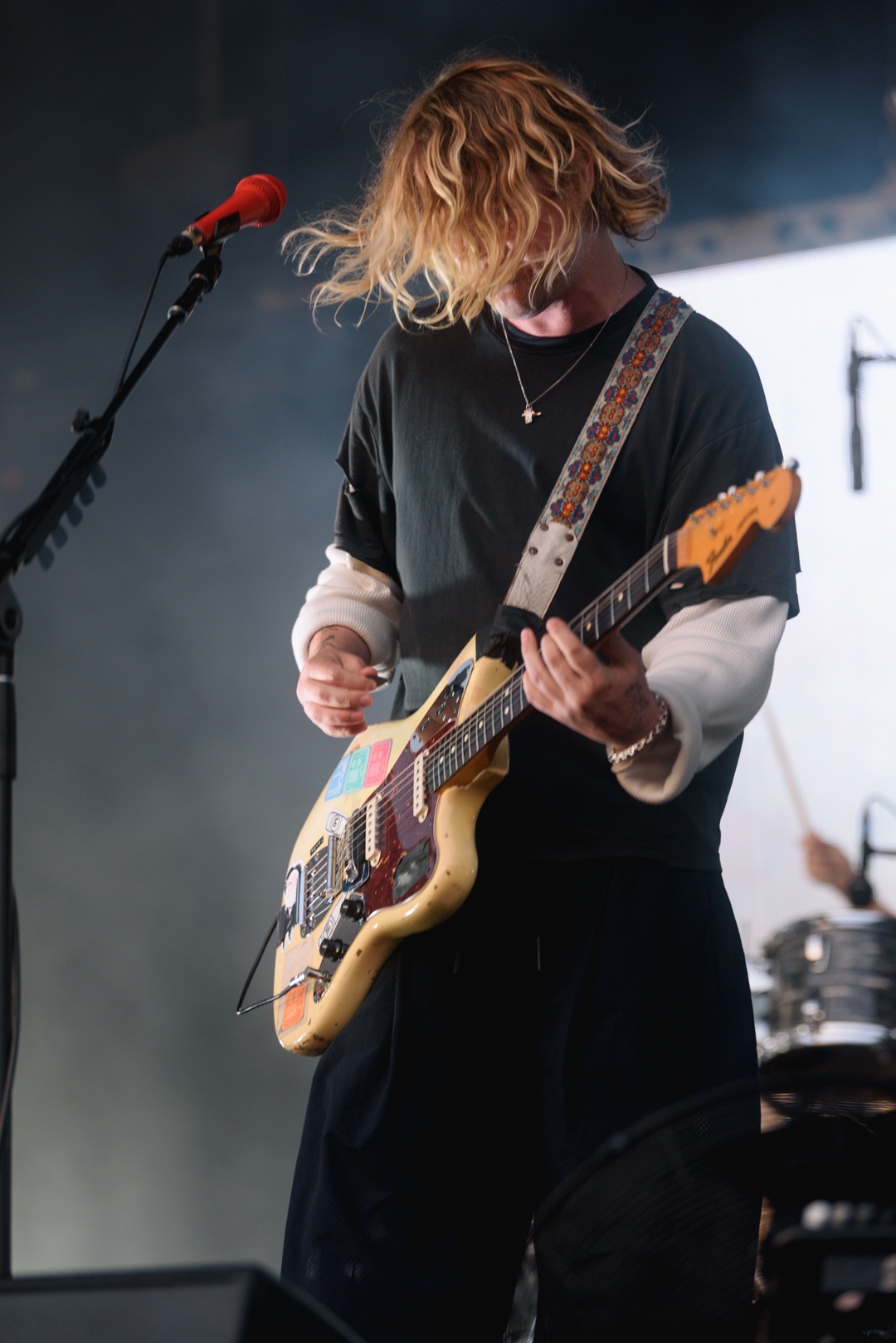 Guitarist with long hair performing on stage with electric guitar