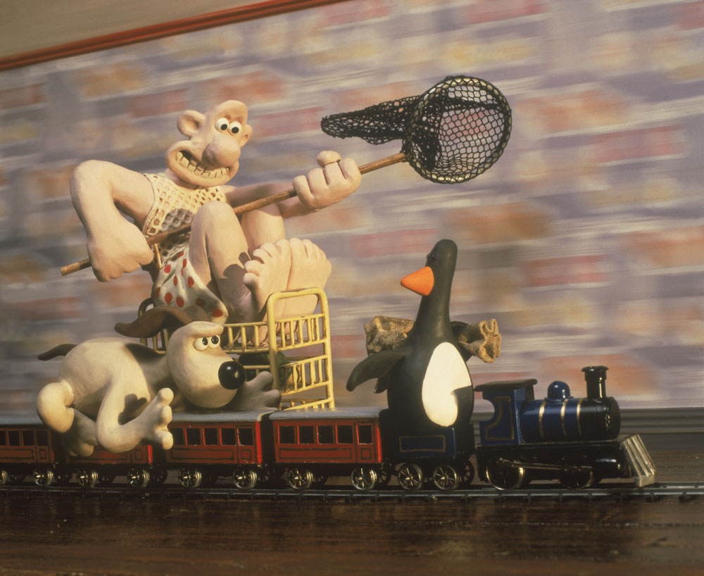 Clay characters on model train with net and penguin