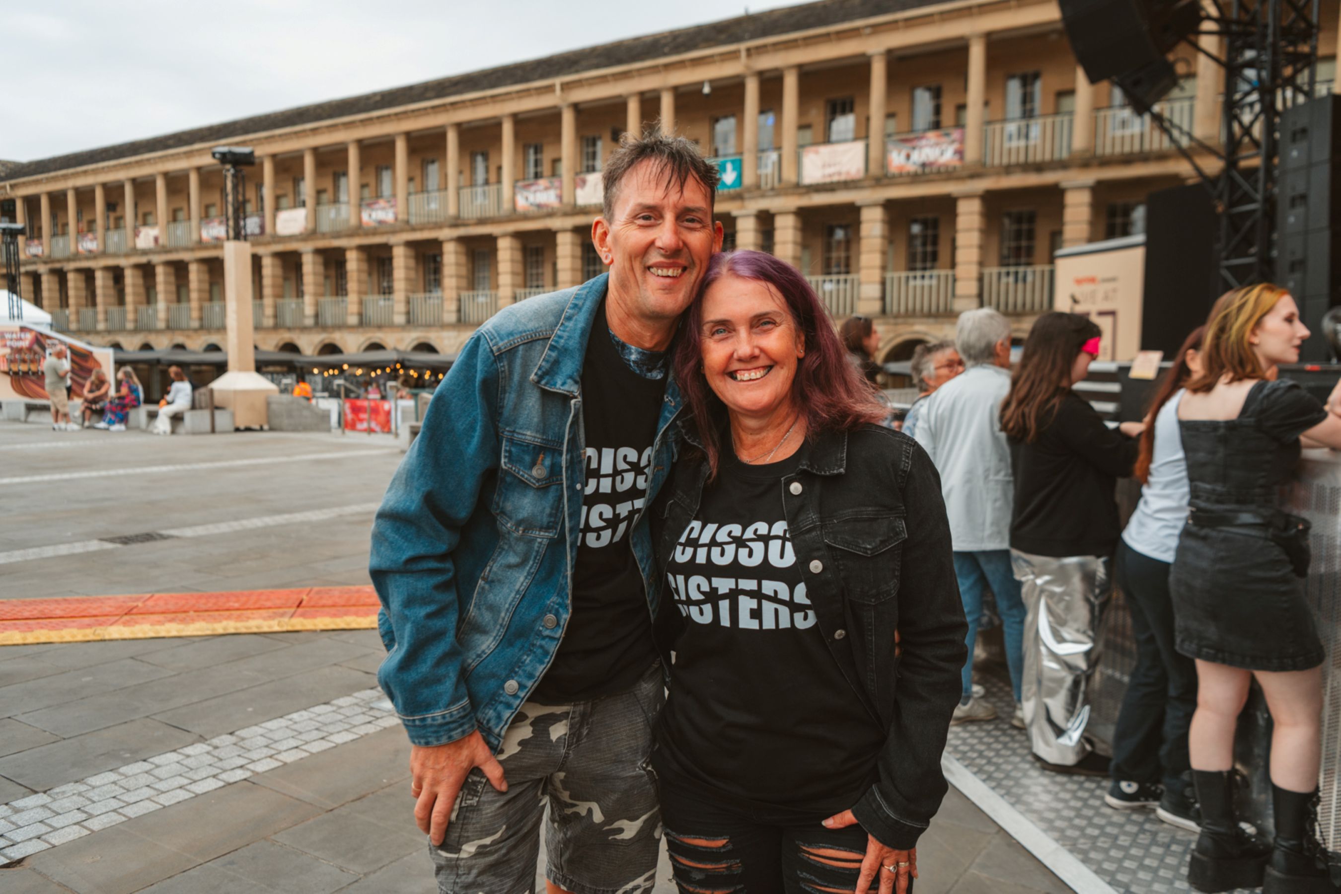 Smiling couple in denim jackets at outdoor event in Halifax