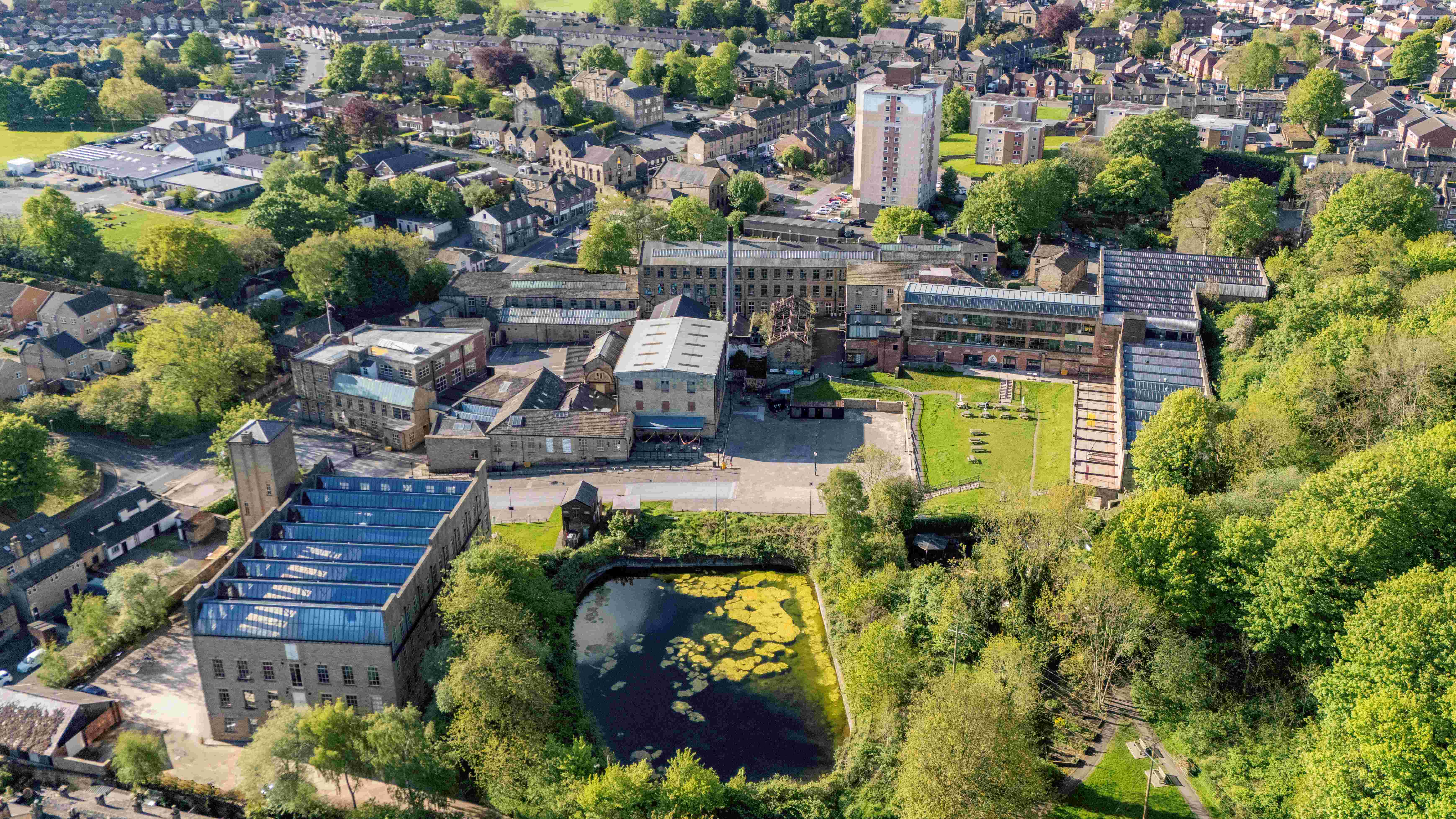 Aerial view of historic mill complex with surrounding trees