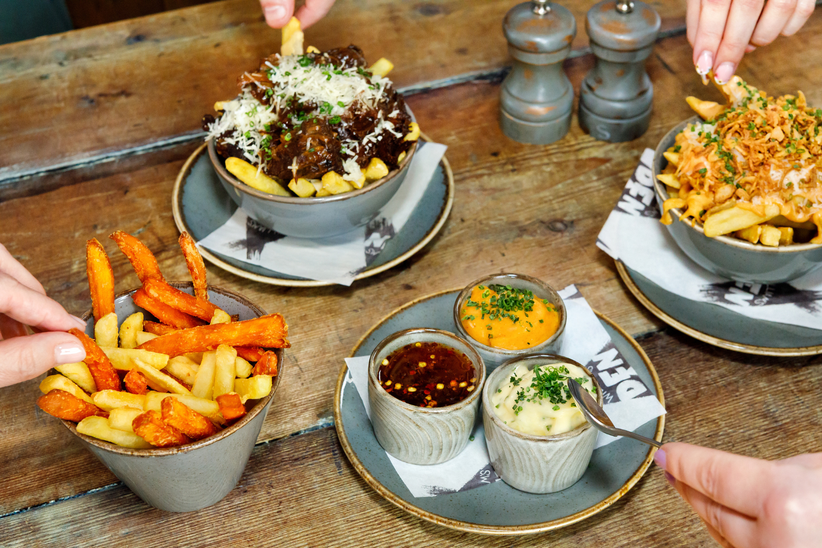 Assorted bowls of chips with toppings on a rustic wooden table