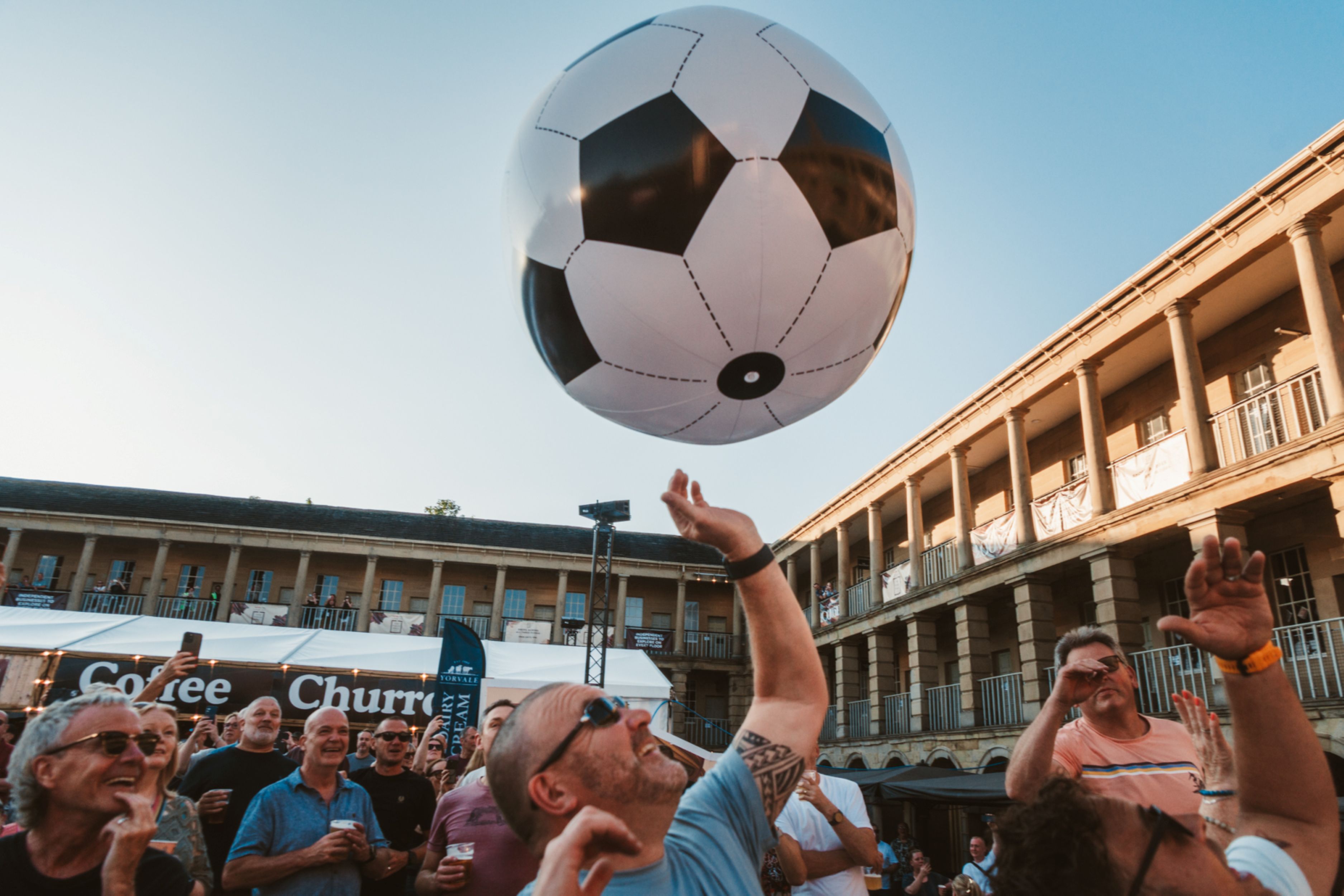 Crowd in Halifax courtyard enjoying giant inflatable soccer ball