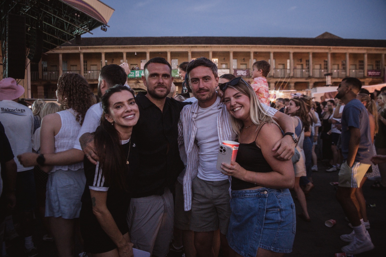 Group of friends enjoying an outdoor concert at dusk