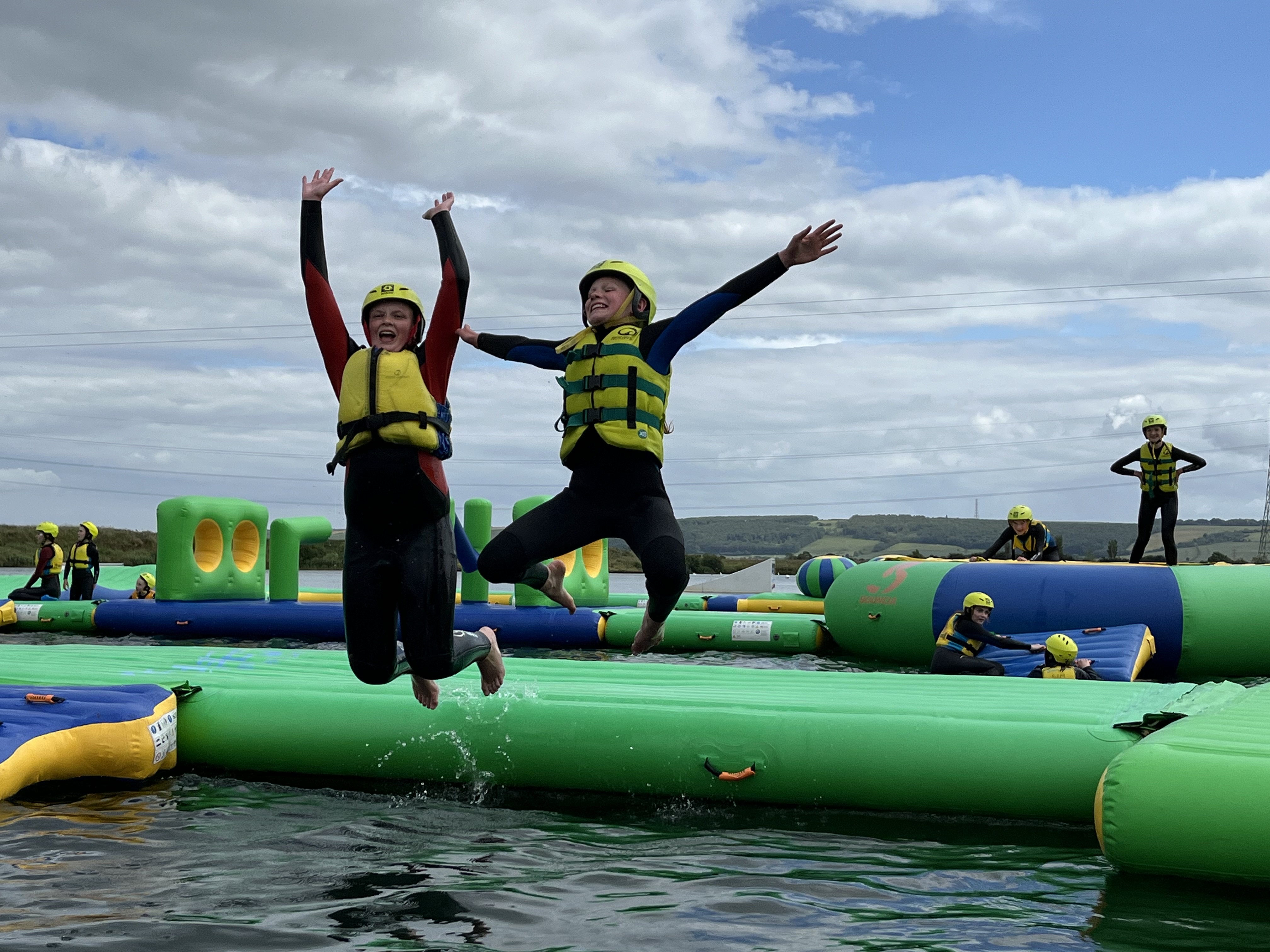 Children in life jackets jumping on inflatable water park