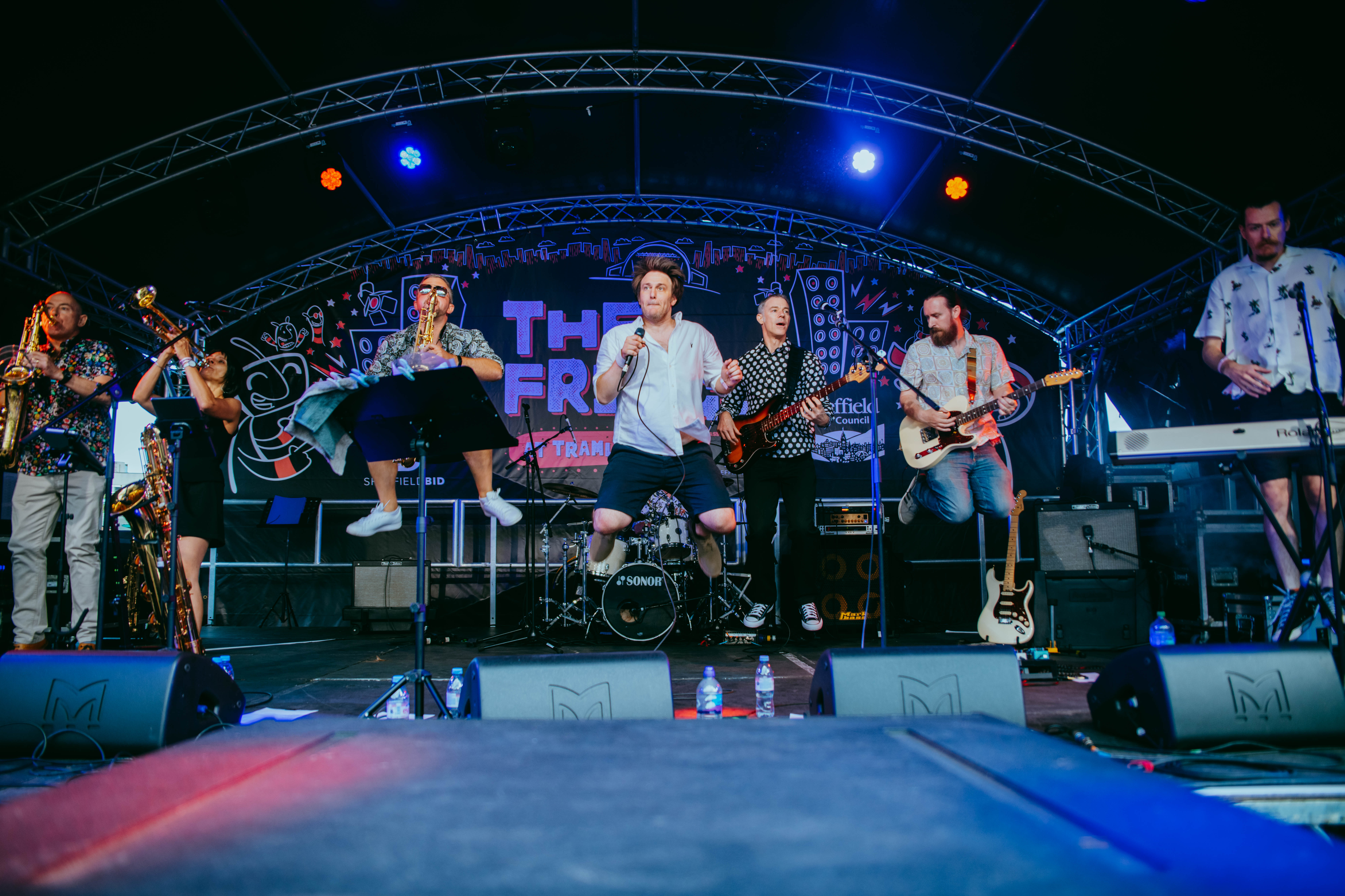 Lively band performing on stage with colorful lights