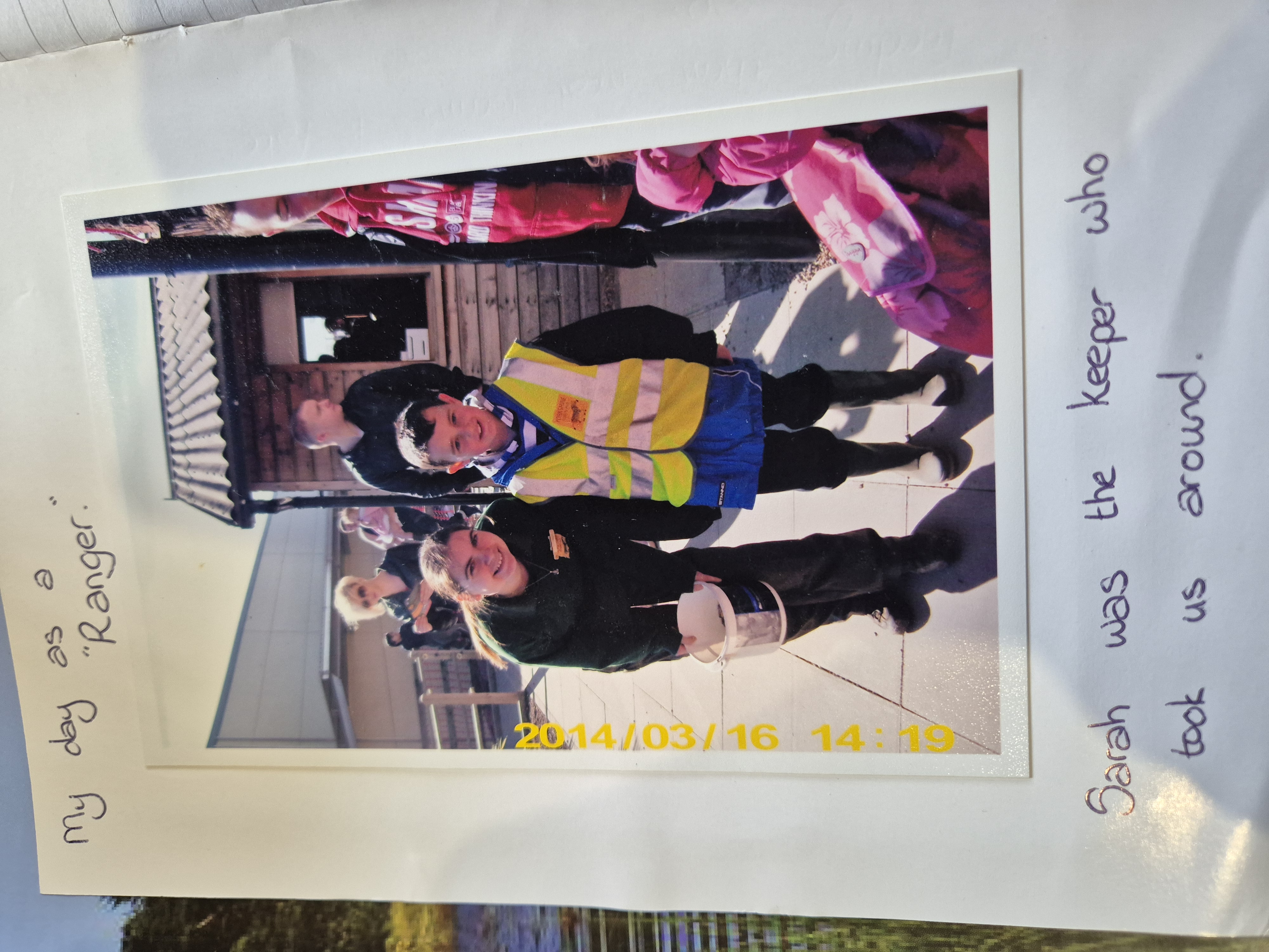 Zoo ranger and child in safety vest smiling outdoors