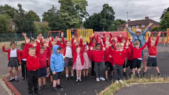 Group of joyful schoolchildren in red uniforms at a playground