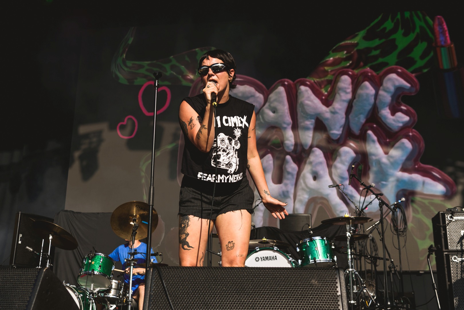 Female singer on stage with vibrant graffiti backdrop