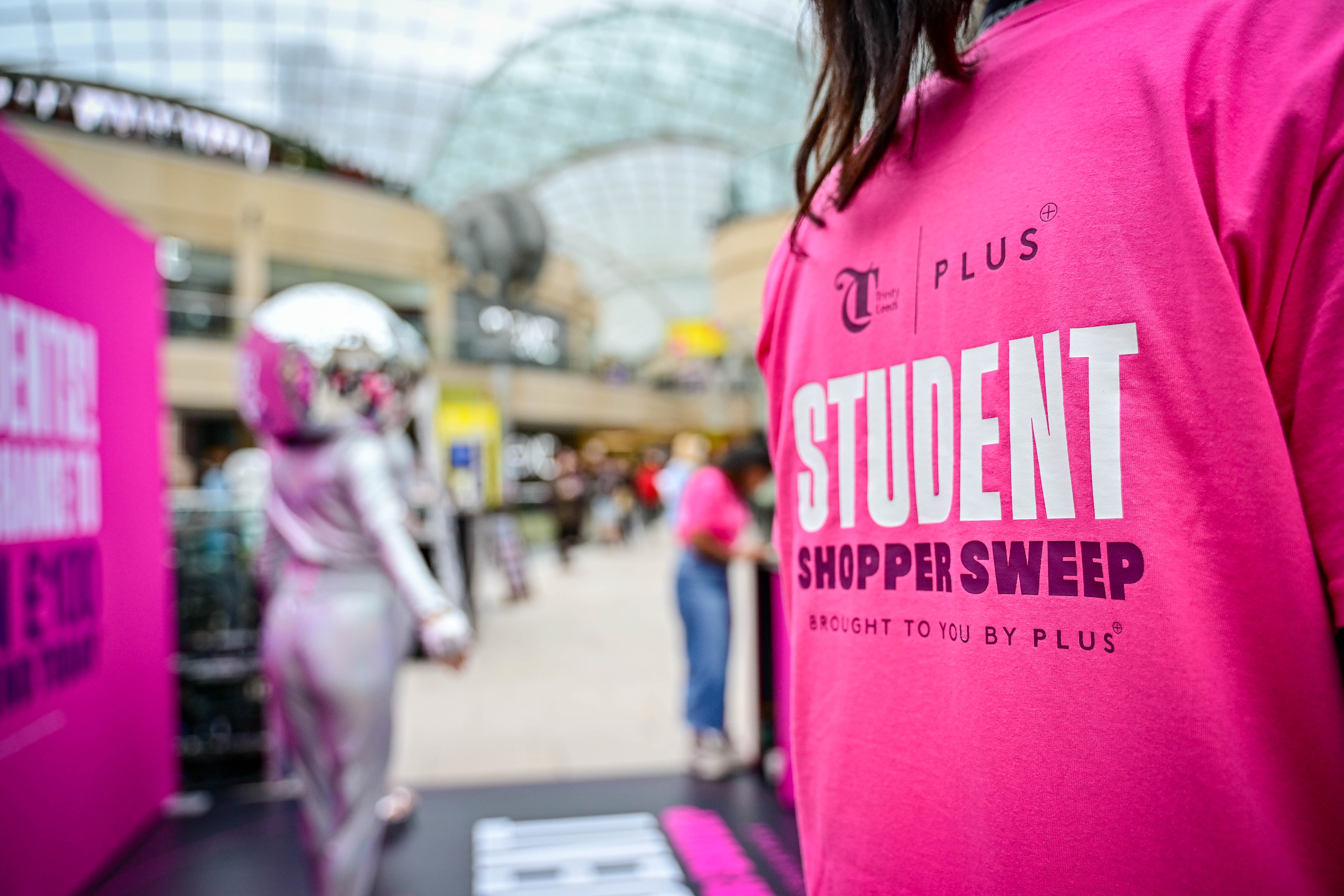 Person in bright pink shirt at indoor shopping event
