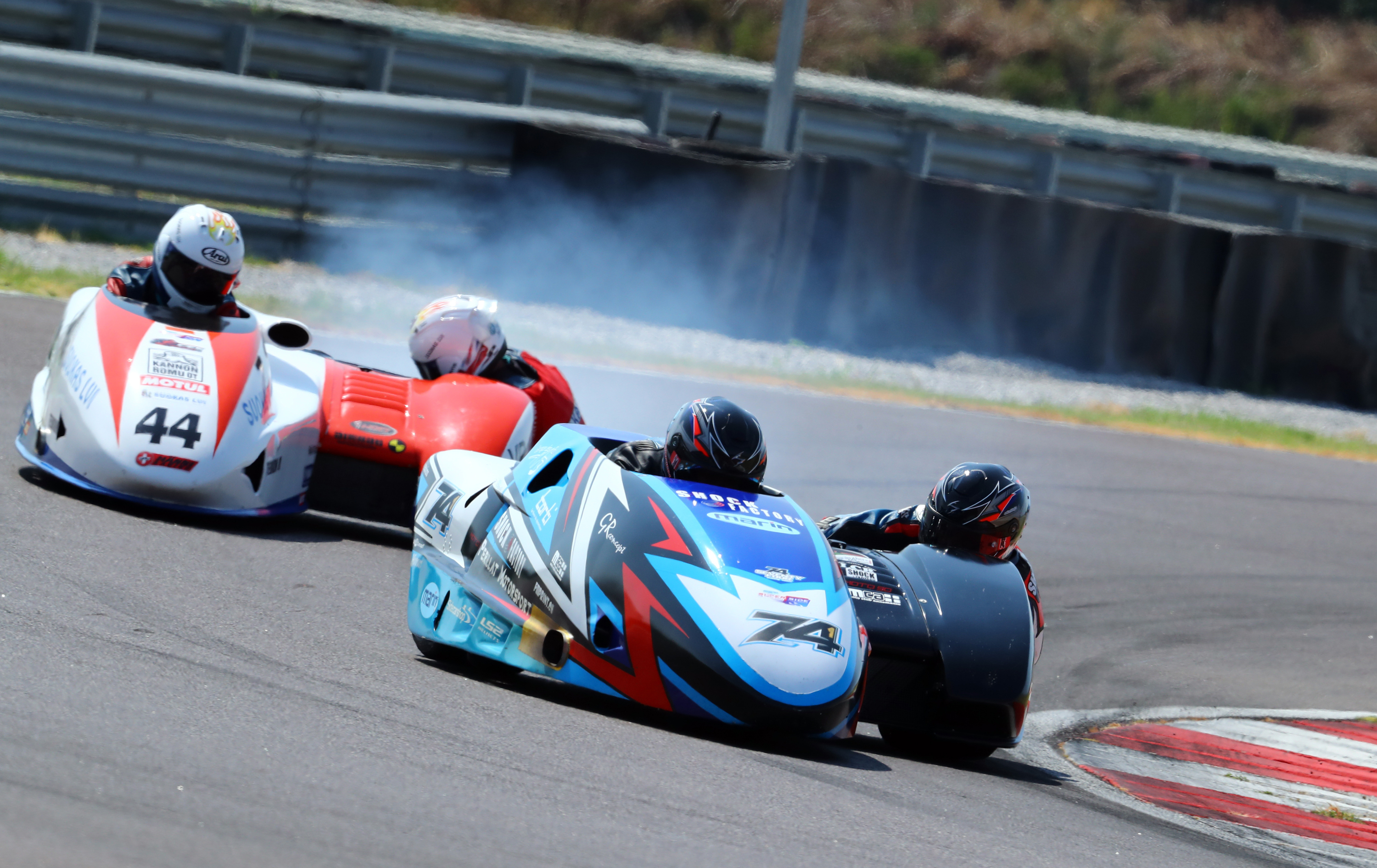 Motorcycle sidecar race on curved track with three competitors