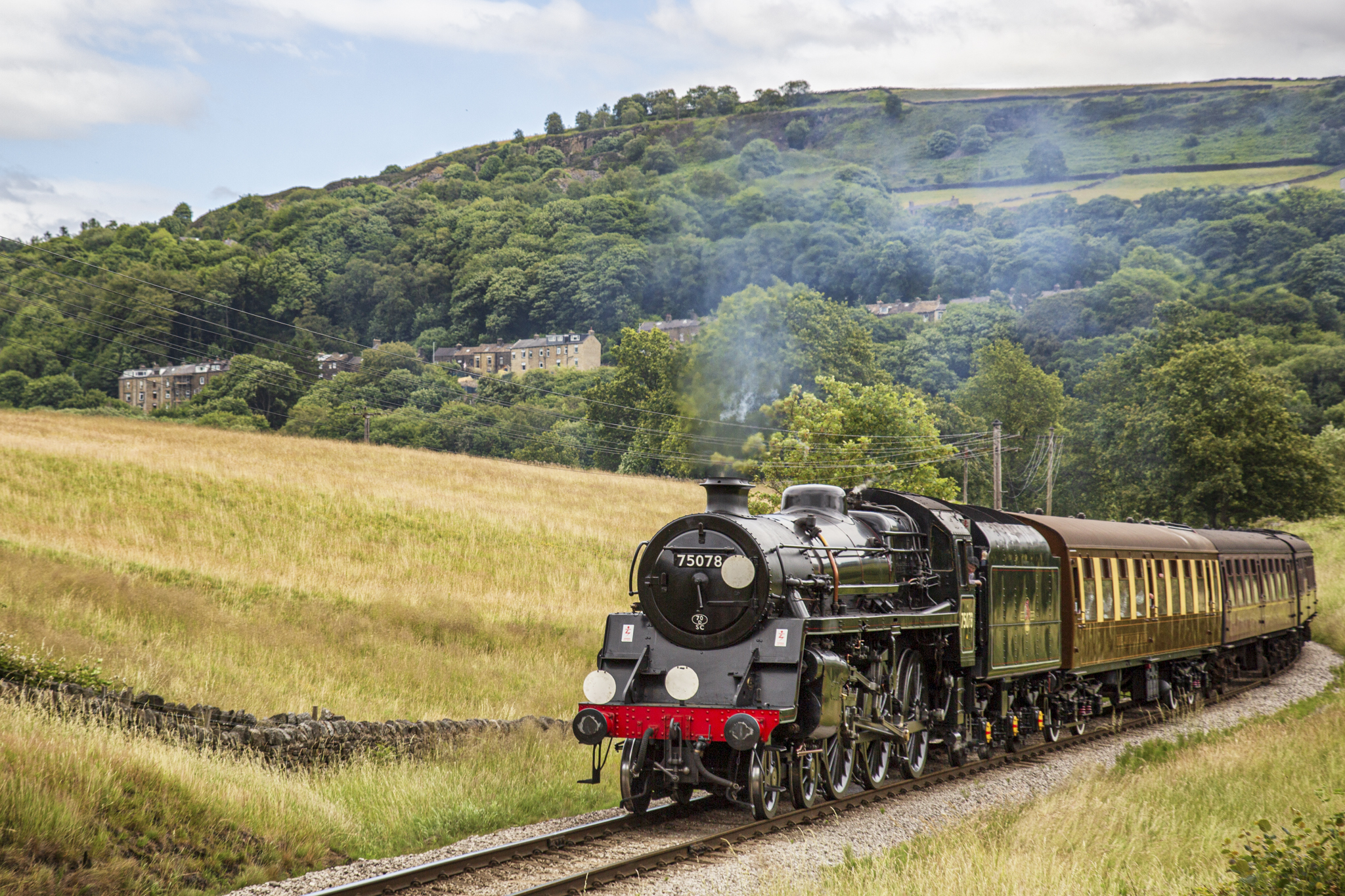 Historic steam train travelling through lush Yorkshire countryside