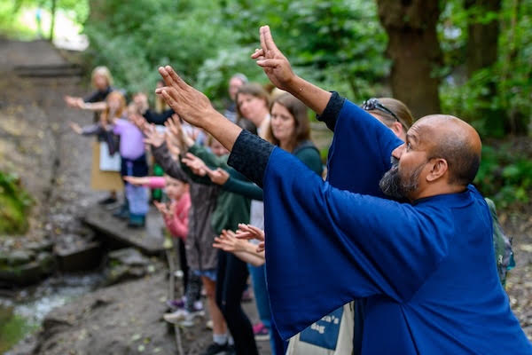 Group of people in woodland following a guide's gestures