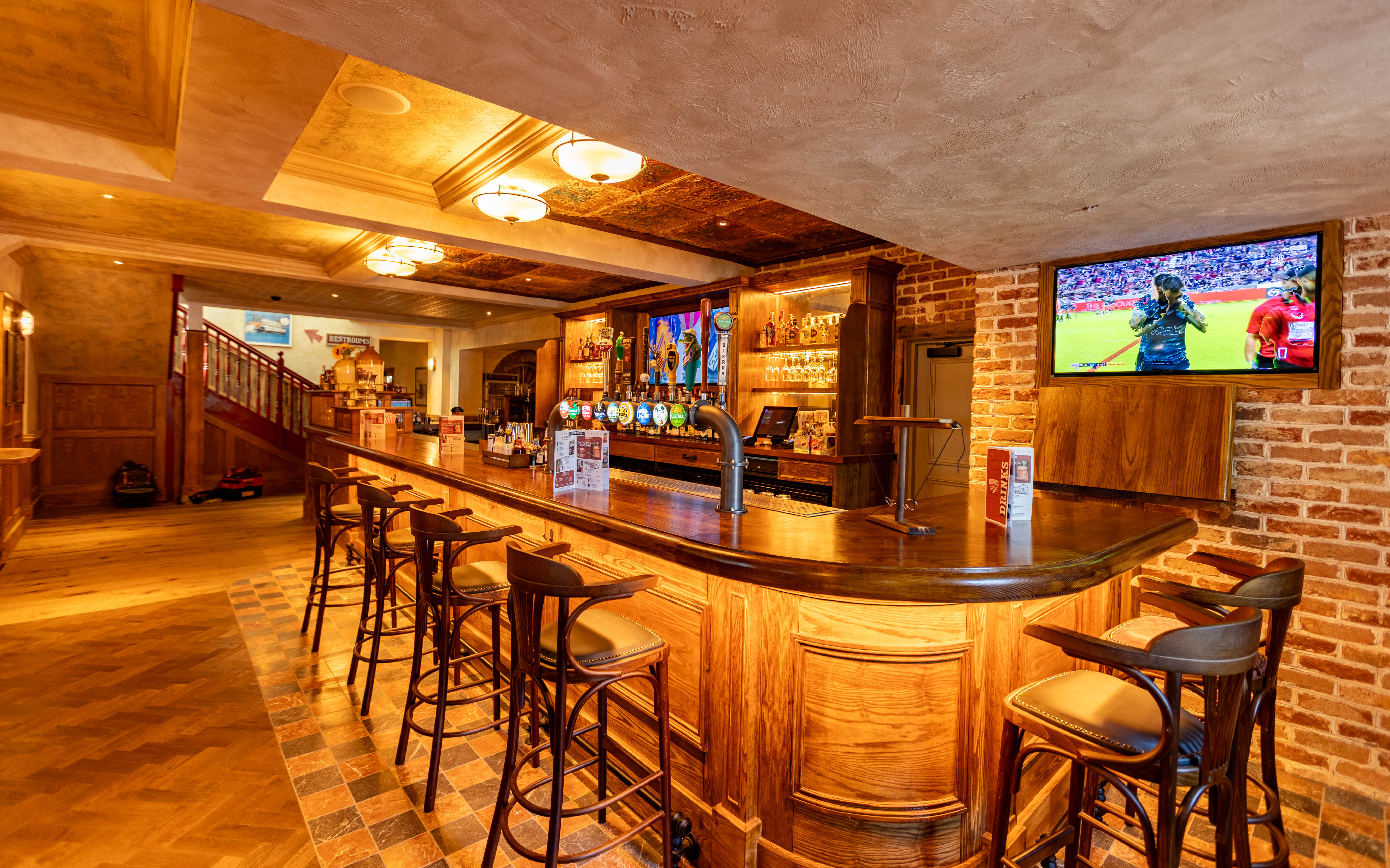 Cosy Yorkshire pub interior with wooden bar, stools, and brick walls